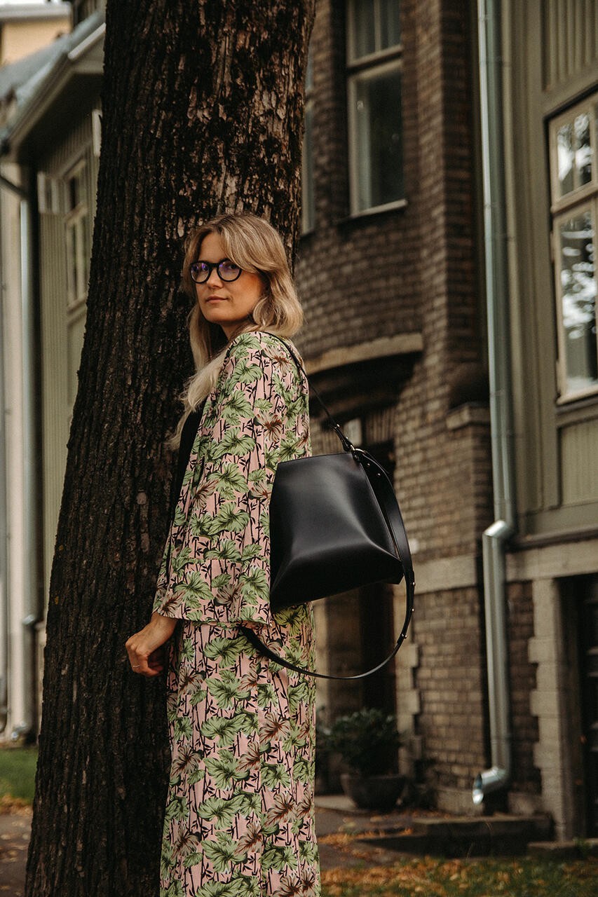Sac à main en cuir noir Stella Soomlais, porté à l'épaule avec bandoulière longue