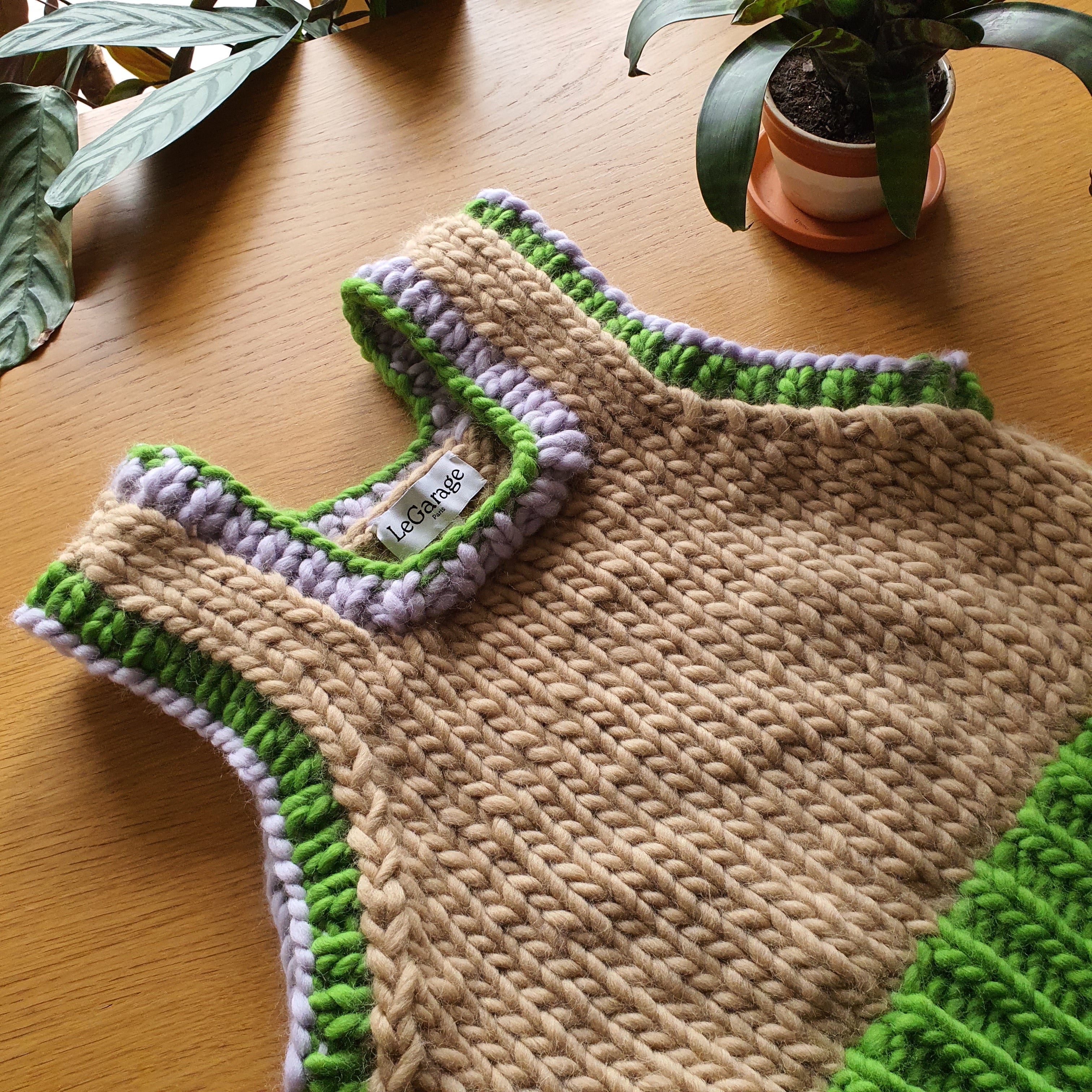 Détail du col et des emmanchures d'un pull en laine tricotée main, maille texturée écrue