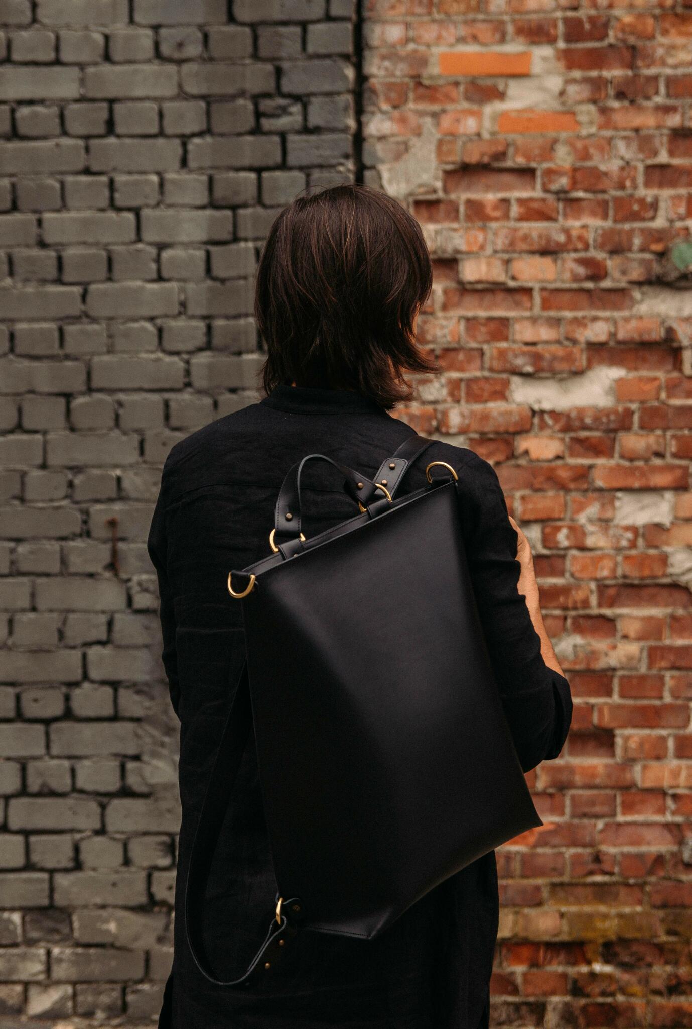 Sac à dos en cuir noir Stella Soomlais porté sur le dos, anneaux laiton en détail