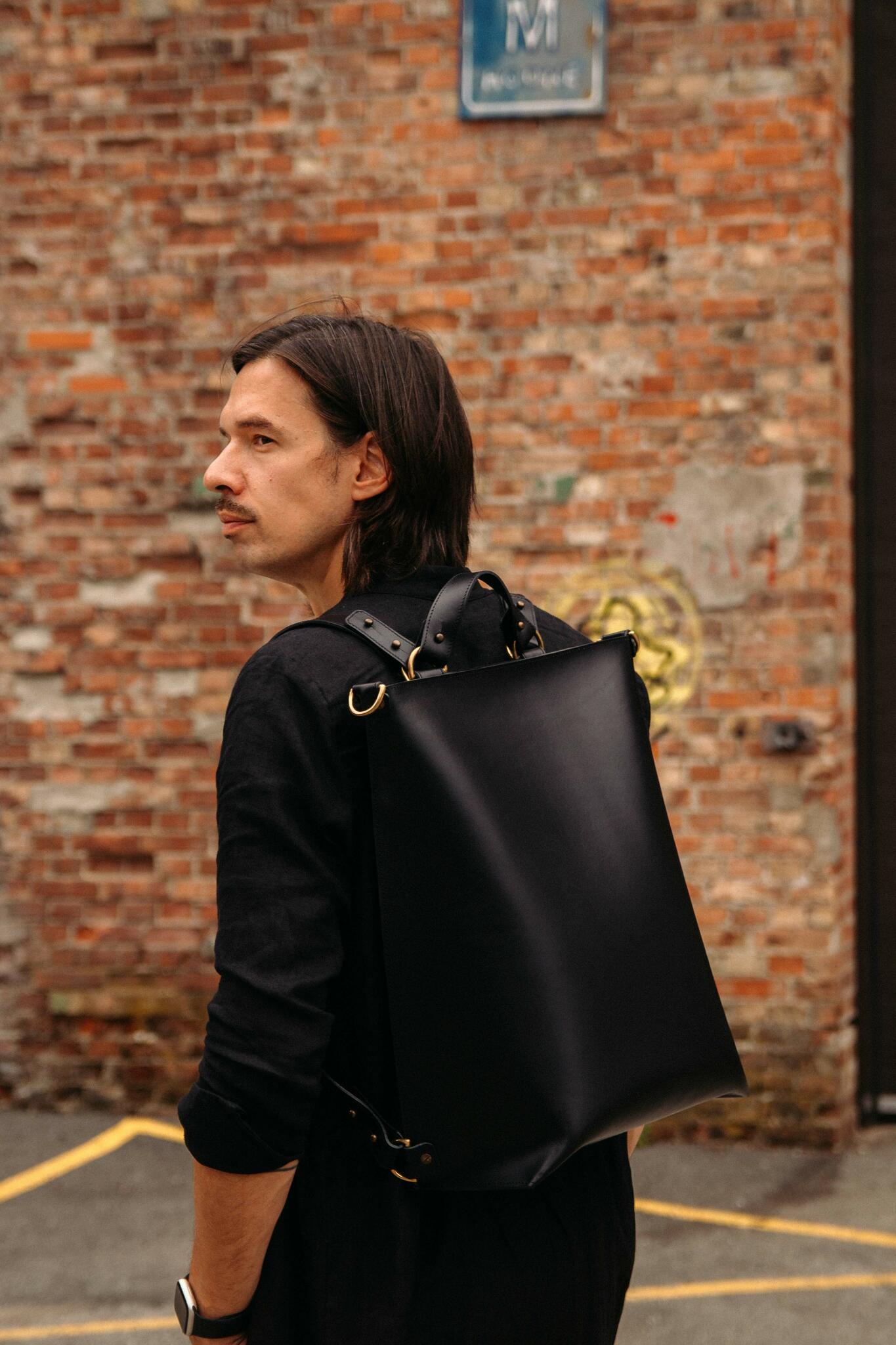 Sac à dos en cuir noir Stella Soomlais porté sur le dos, vue de profil