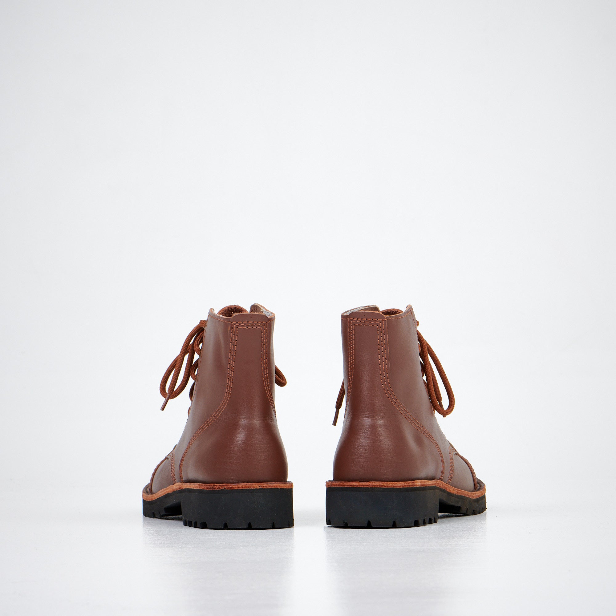 Bottines en cuir marron fait main portées, ambiance intérieure salon