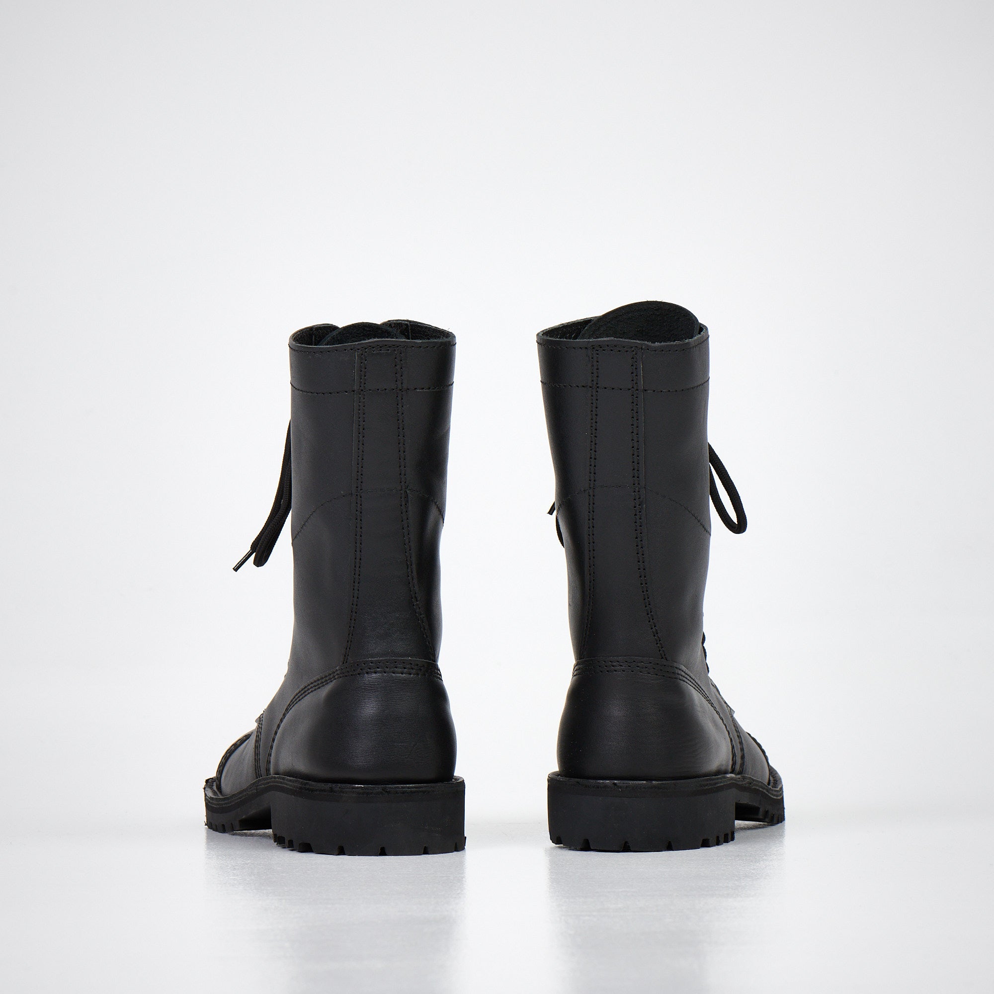 Bottines en cuir noir fait main portées, ambiance intérieure décorée