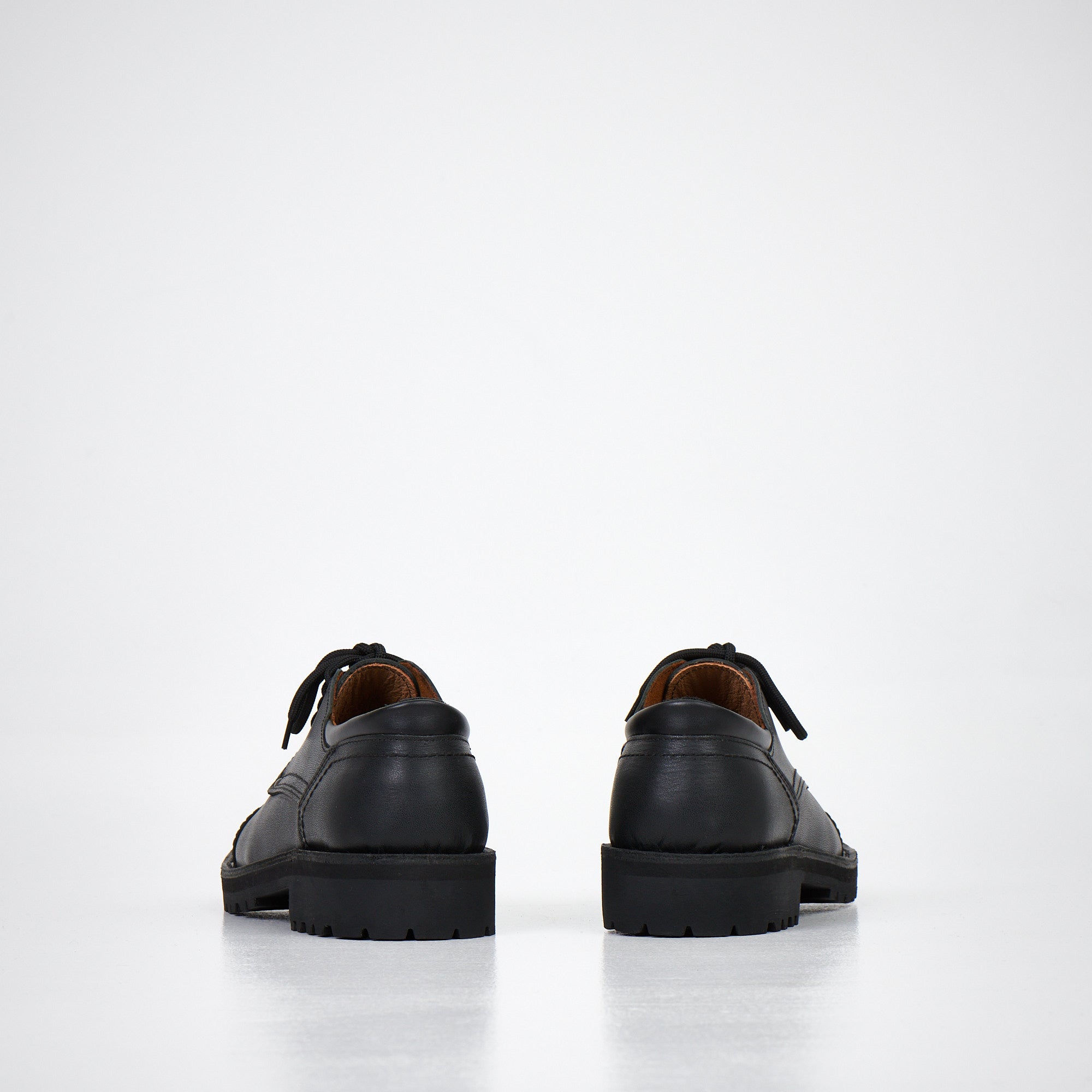 Chaussures derby en cuir noir fait main portées, ambiance lifestyle