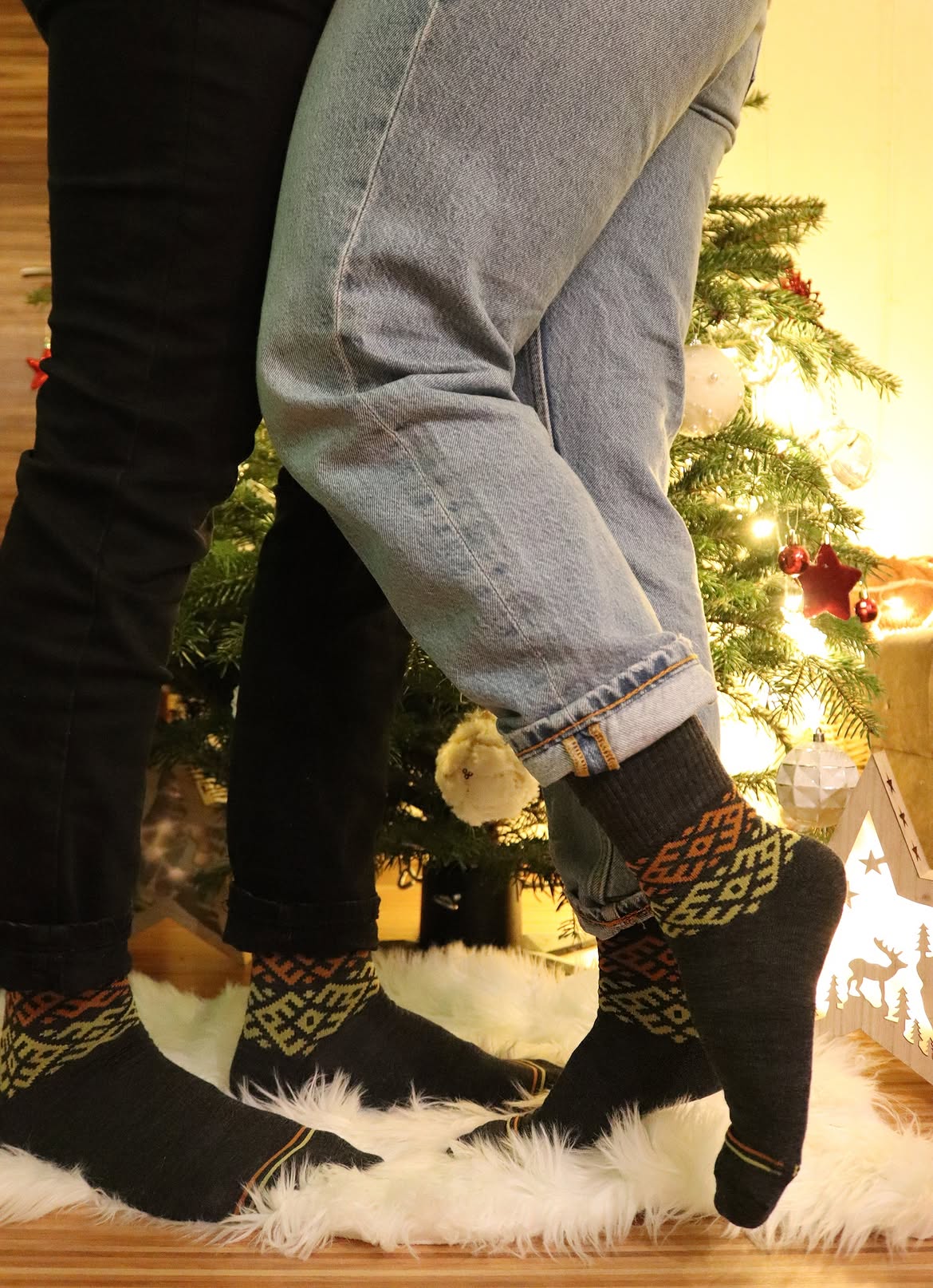 Chaussettes en laine mérinos gris anthracite à motifs orange et verts portées avec un jean, Baltland