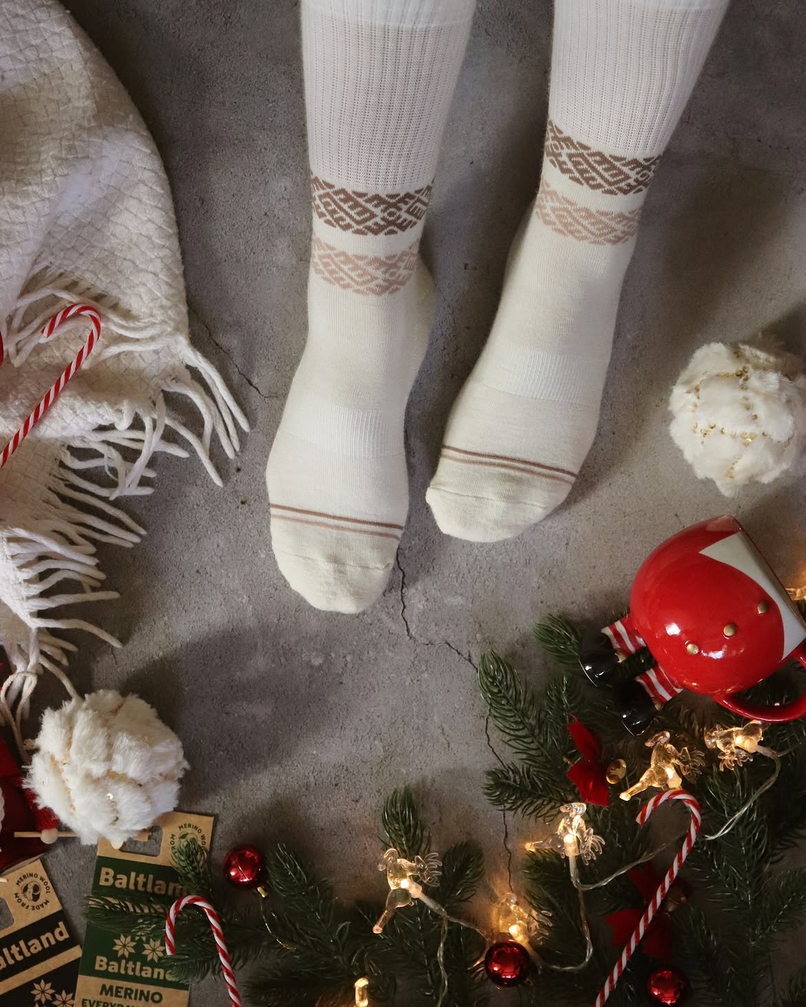 Chaussettes en laine mérinos blanches à motifs géométriques portées dans une ambiance de fêtes, Baltland