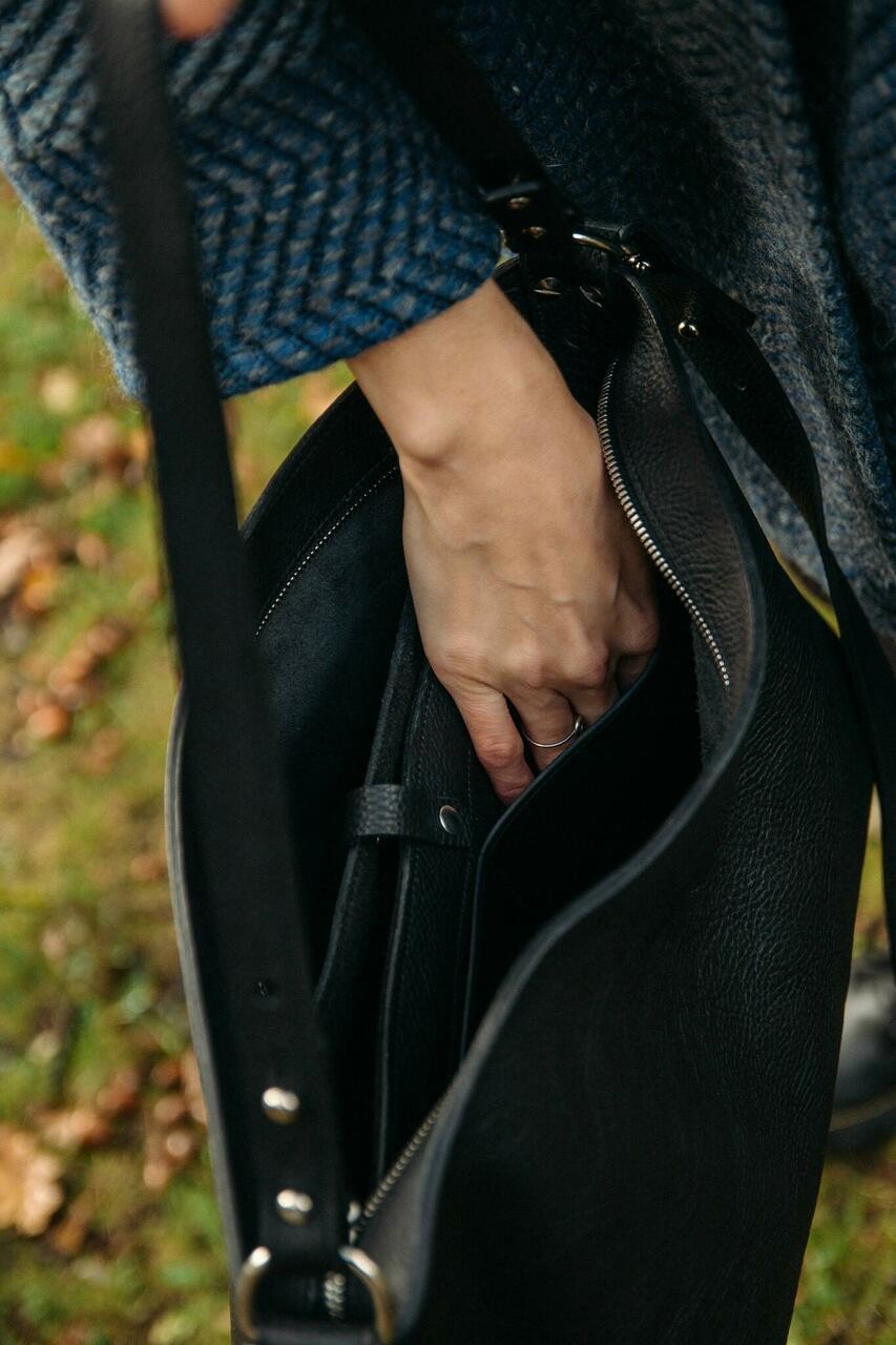 Sac à main en cuir noir Nothing to Declare Stella Soomlais, main plongeant dans le sac ouvert