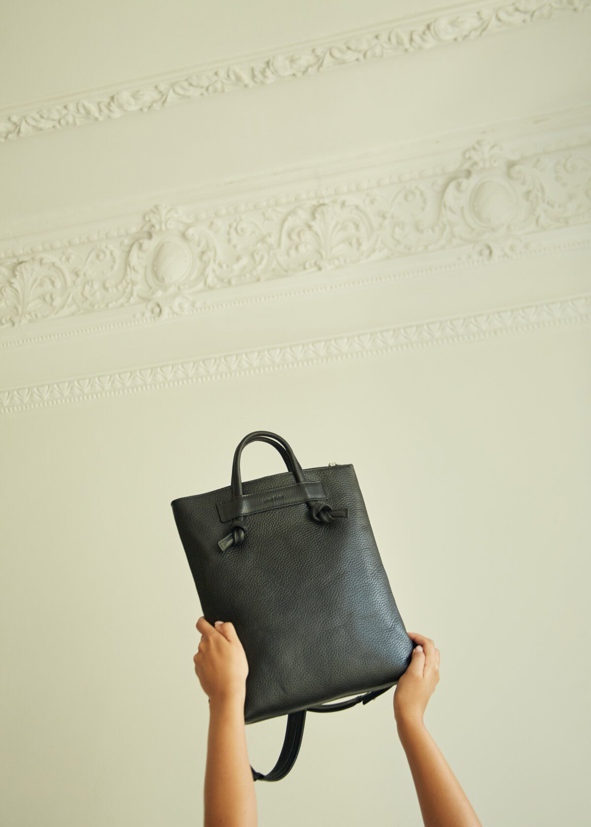 Sac à dos minimaliste en cuir marron porté par un homme, photo lifestyle