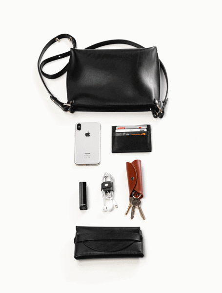 Sac à main en cuir noir Stella Soomlais, démonstration de sa contenance : téléphone, clés, écouteurs et porte-cartes