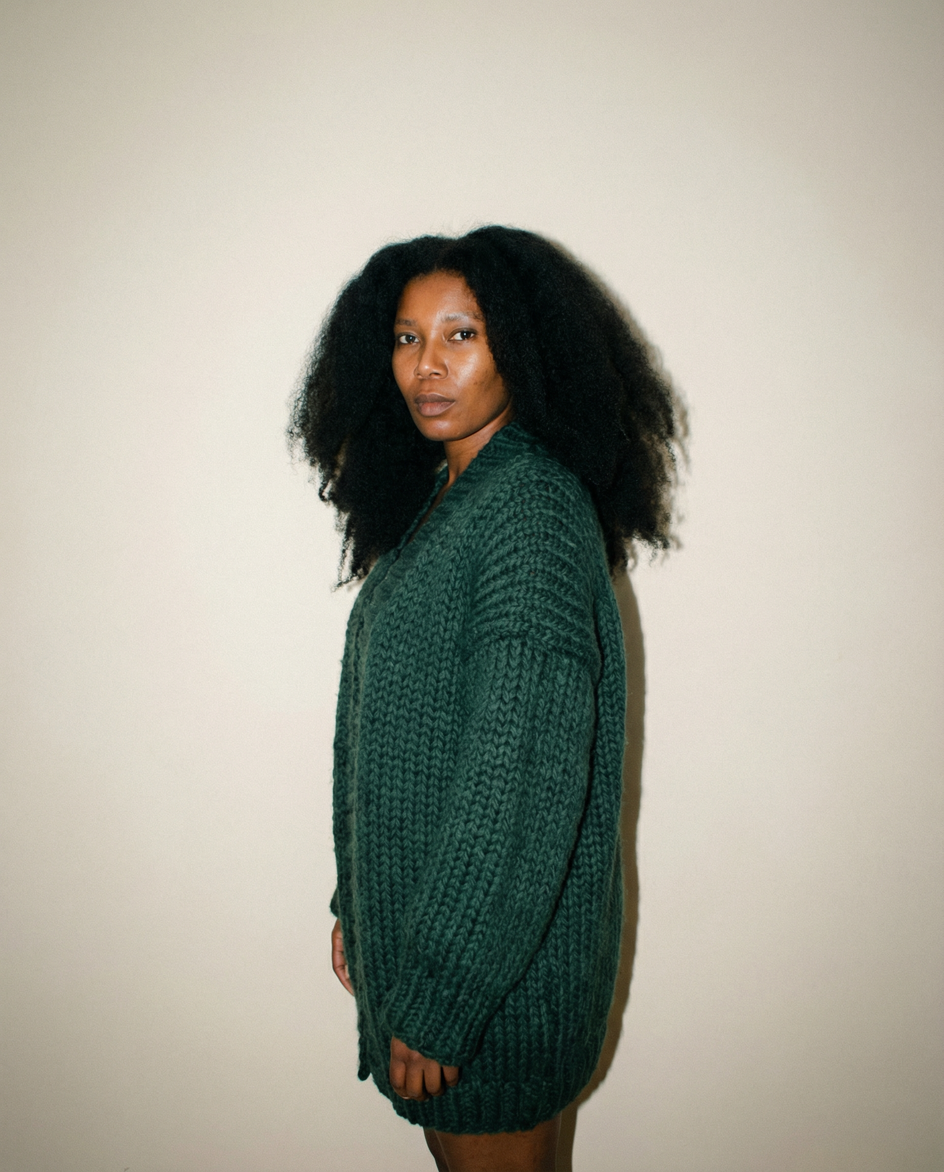 Cardigan en laine vert forêt tricoté main LeGarage Knitwear, vue de profil sur mannequin