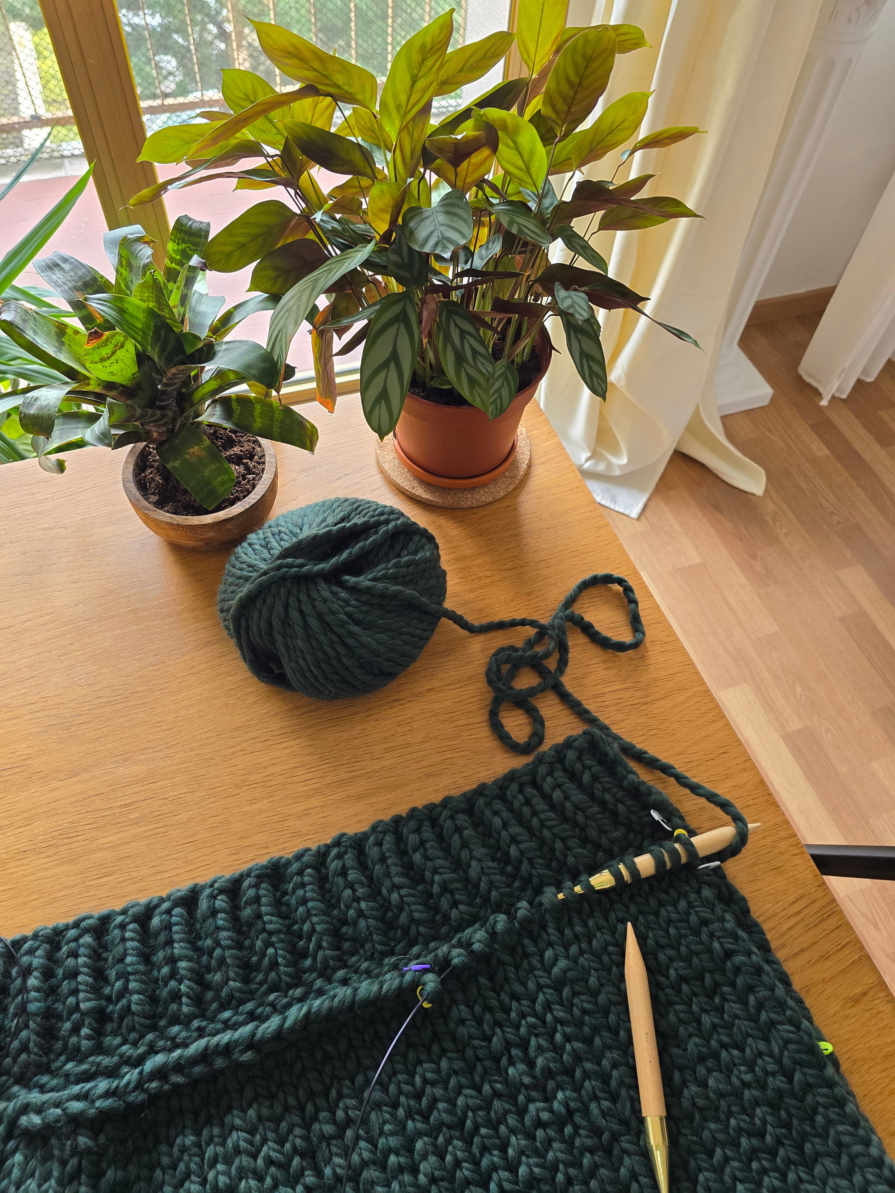 Cardigan en laine vert sapin tricoté main, vue de face sur mannequin en intérieur épuré