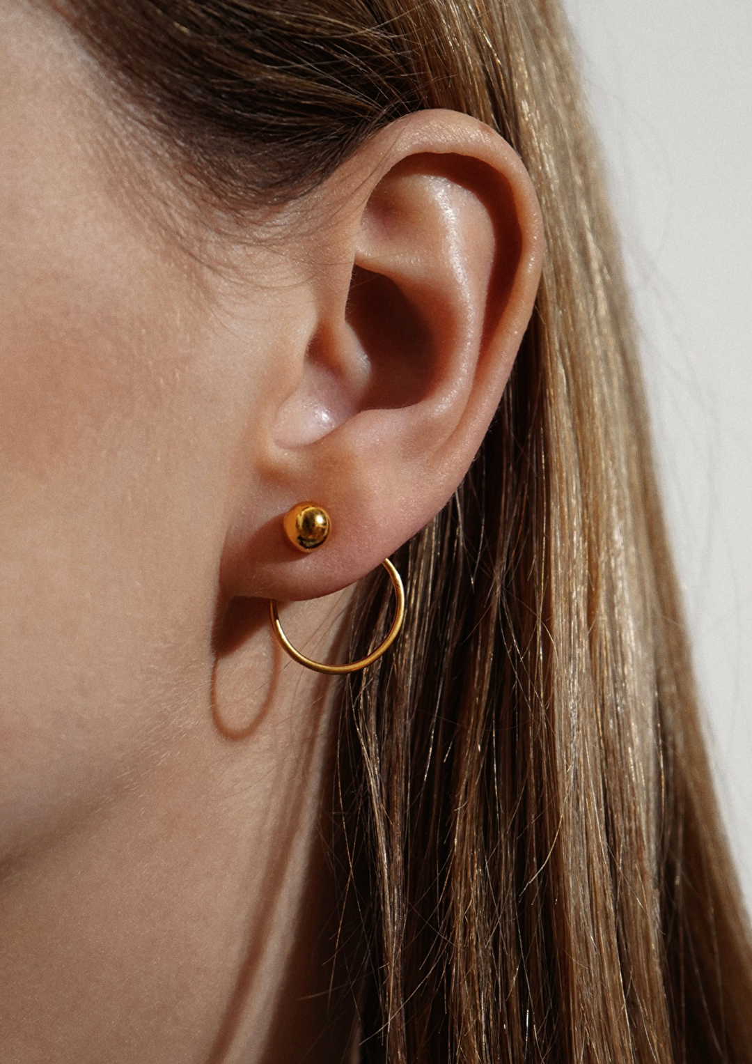 Boucles d'oreilles NO MORE Chord en plaqué or, portées par femme aux cheveux longs
