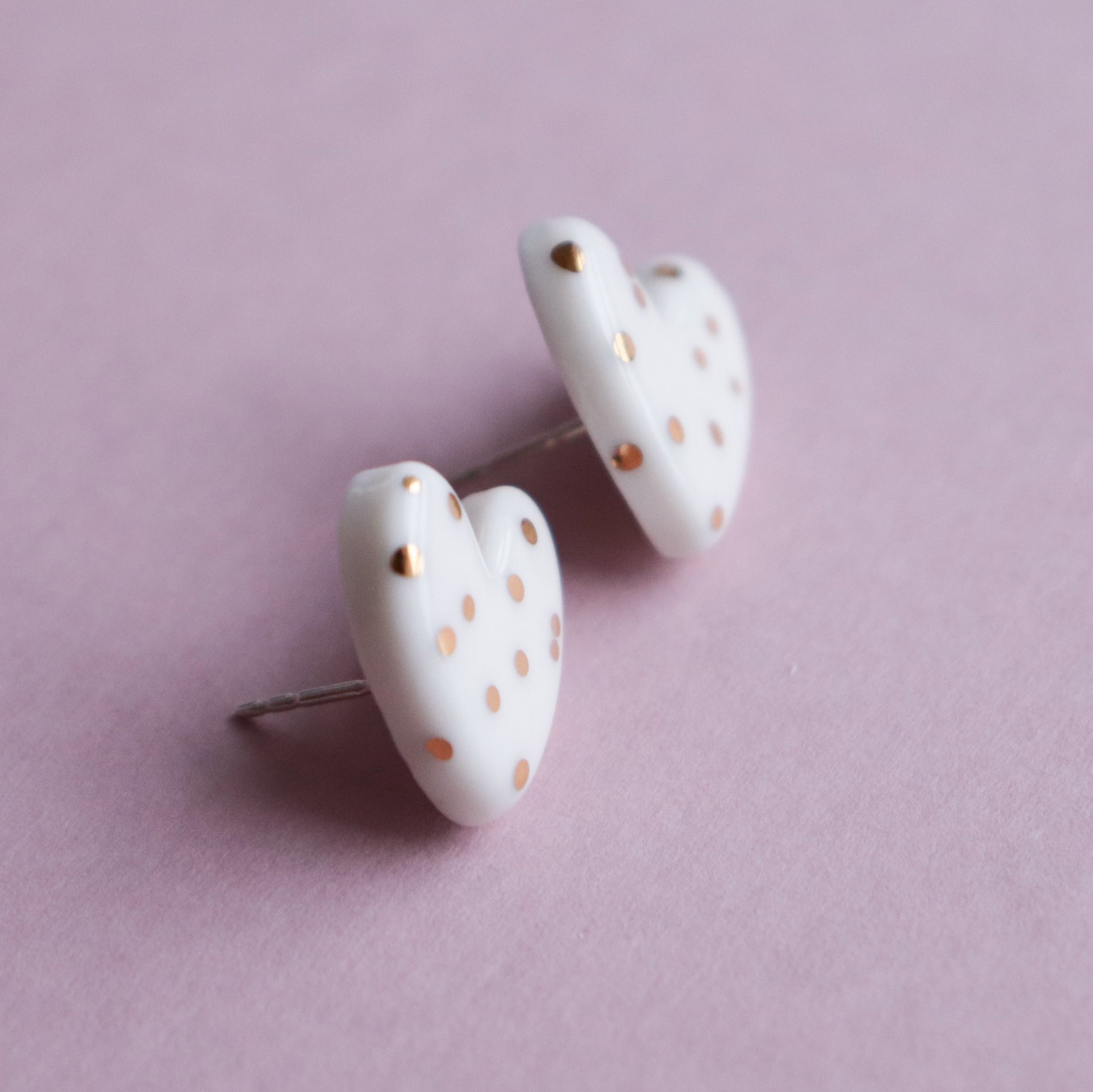 Puces d'oreilles cœur en porcelaine pointillée blanche, vue verticale