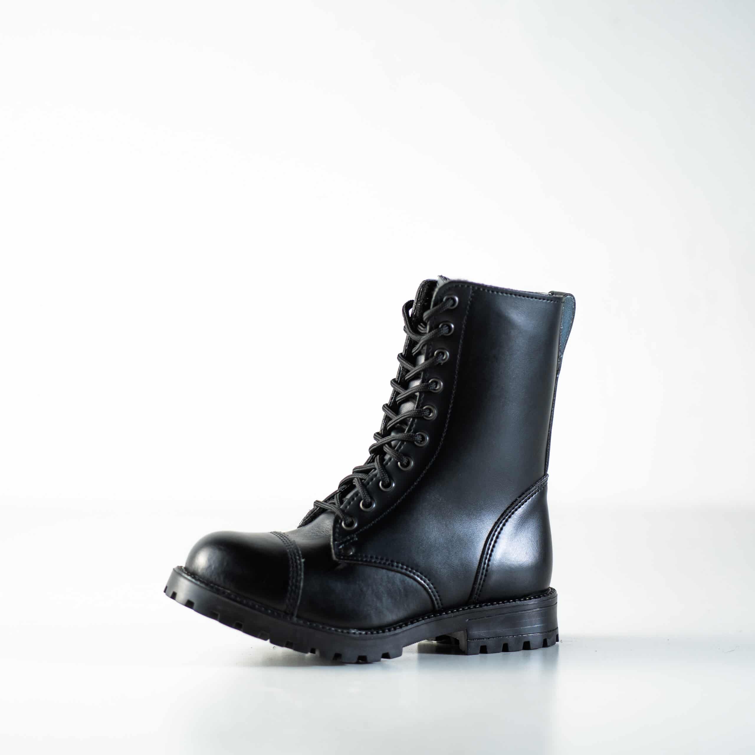 Bottines d'hiver en cuir noir à semelle crantée, vue de profil sur fond studio