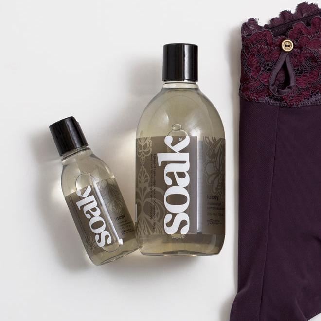 Flacon spray Soak Flatter 248 ml posé devant un fer à repasser blanc, accessoire de finition textile