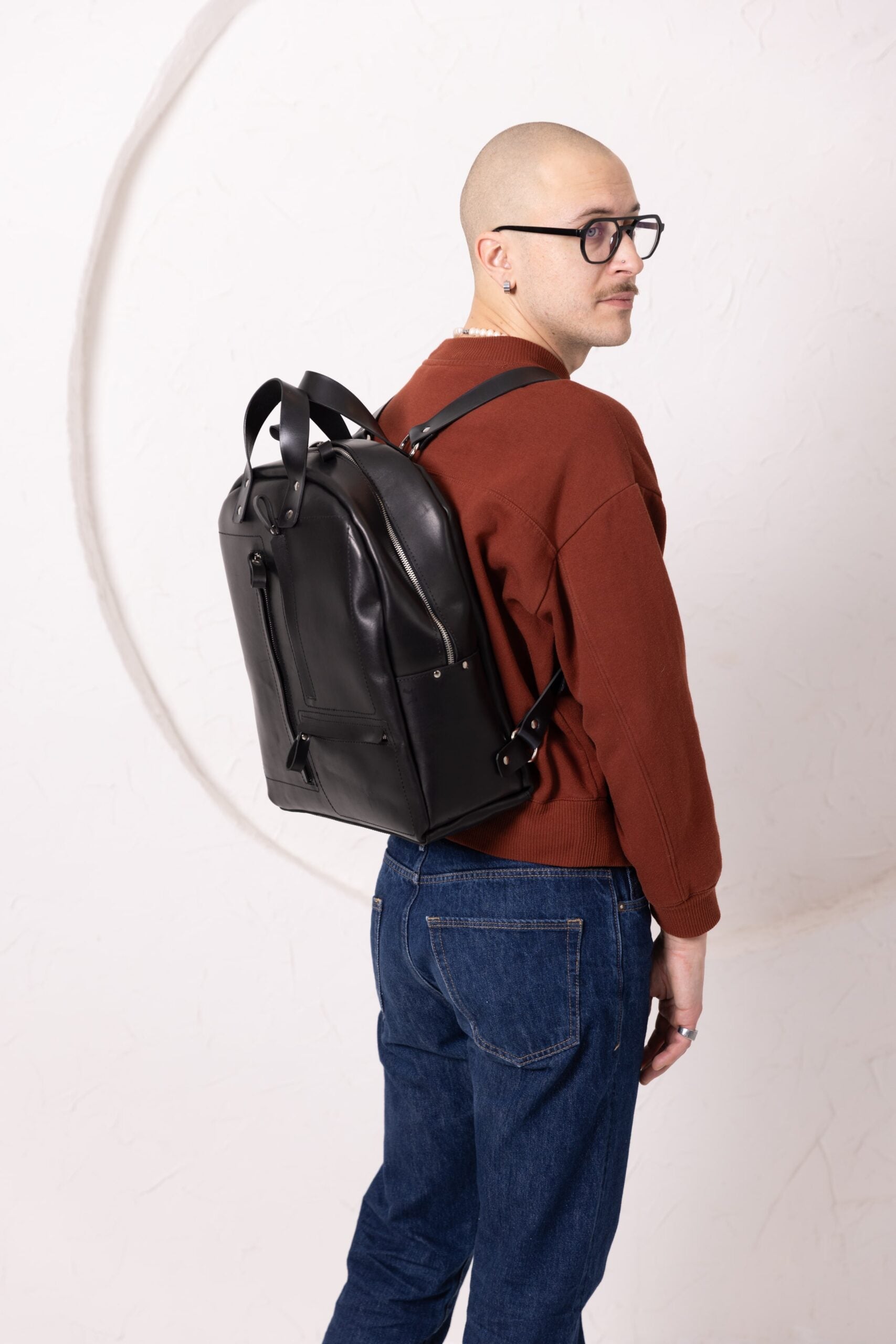 Sac à dos en cuir noir, vue arrière avec compartiments visibles
