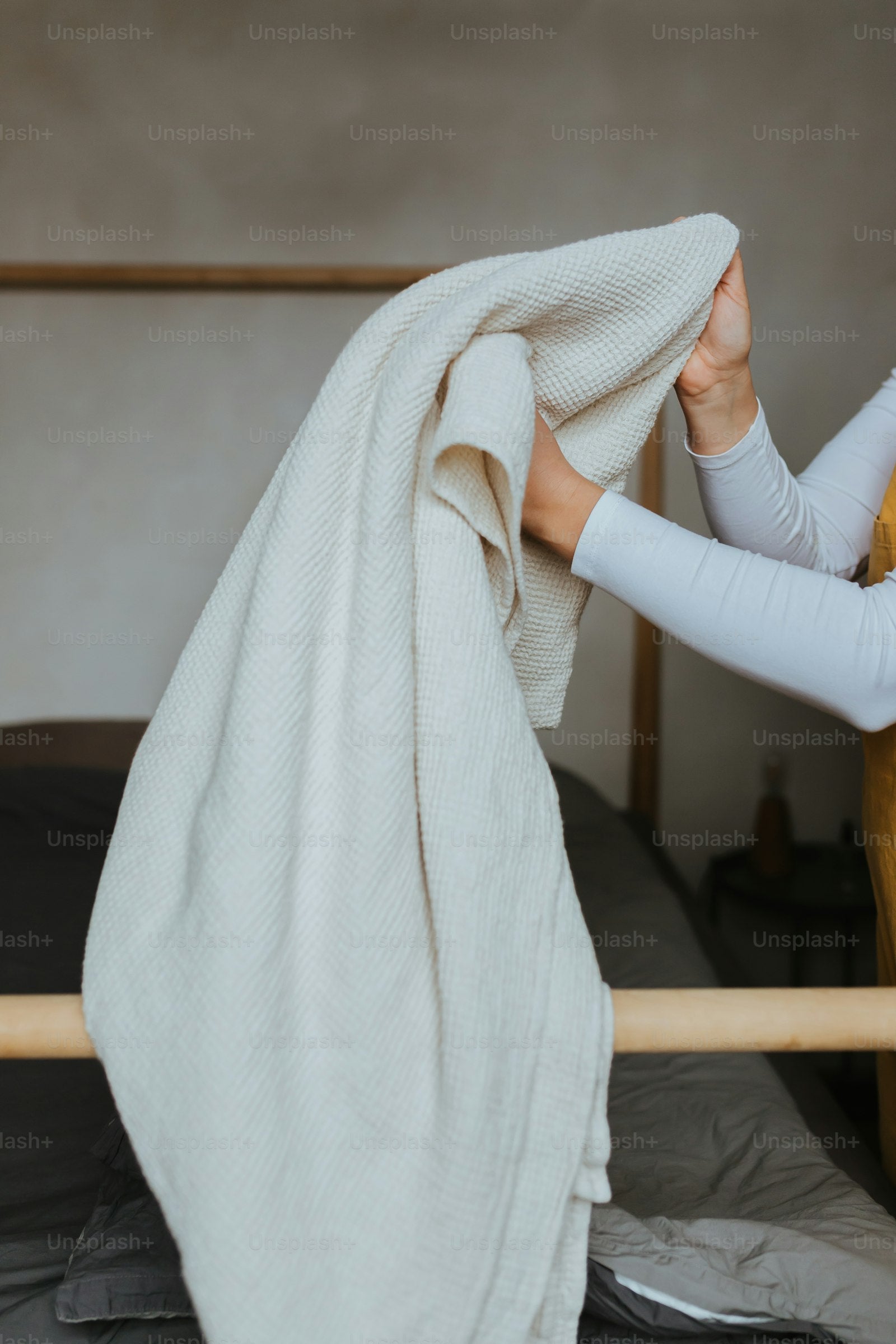 Personne sous une couverture sur un lit, ambiance textile naturel