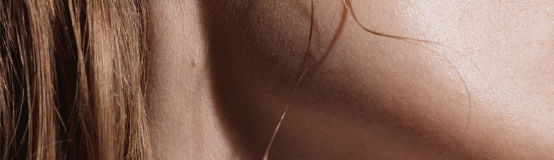 Boucles d'oreilles NO MORE en argent portées par femme cheveux longs, vue d'oreille