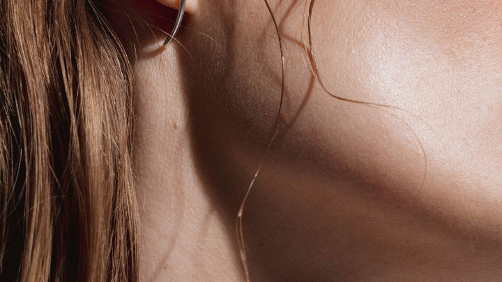 Boucles d'oreilles NO MORE en argent portées par femme cheveux longs, vue d'oreille