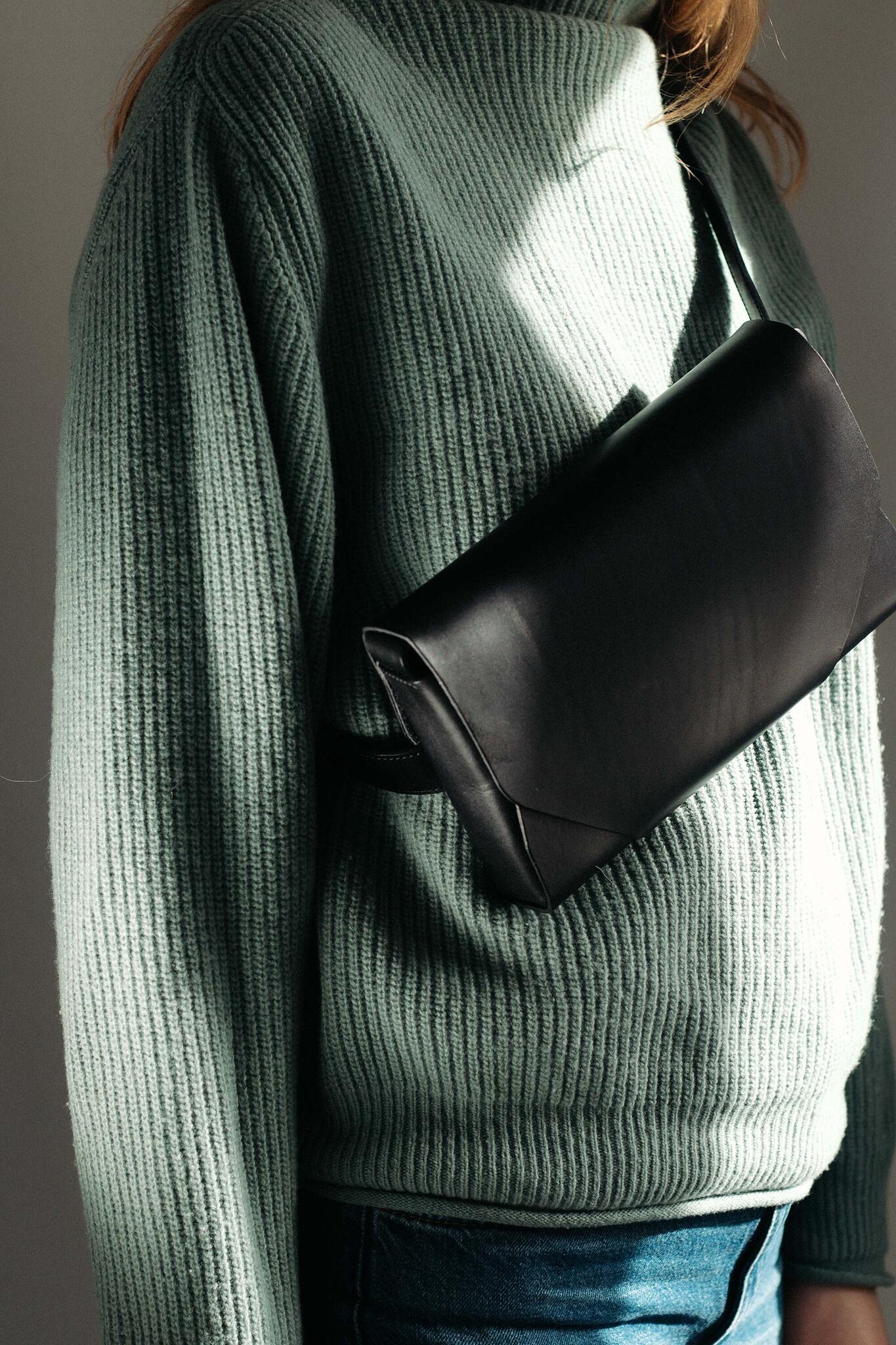 Sac bandoulière en cuir noir Stella Soomlais, gros plan sur le rabat enveloppe porté en travers du buste