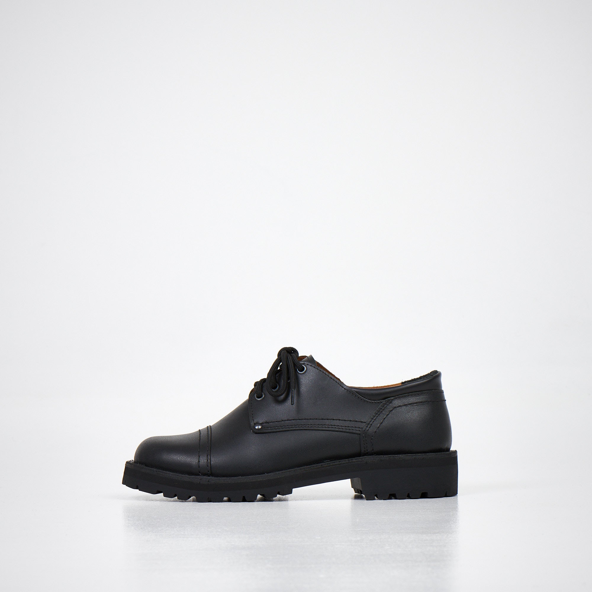 Chaussures derby en cuir noir fait main, vue de profil épurée