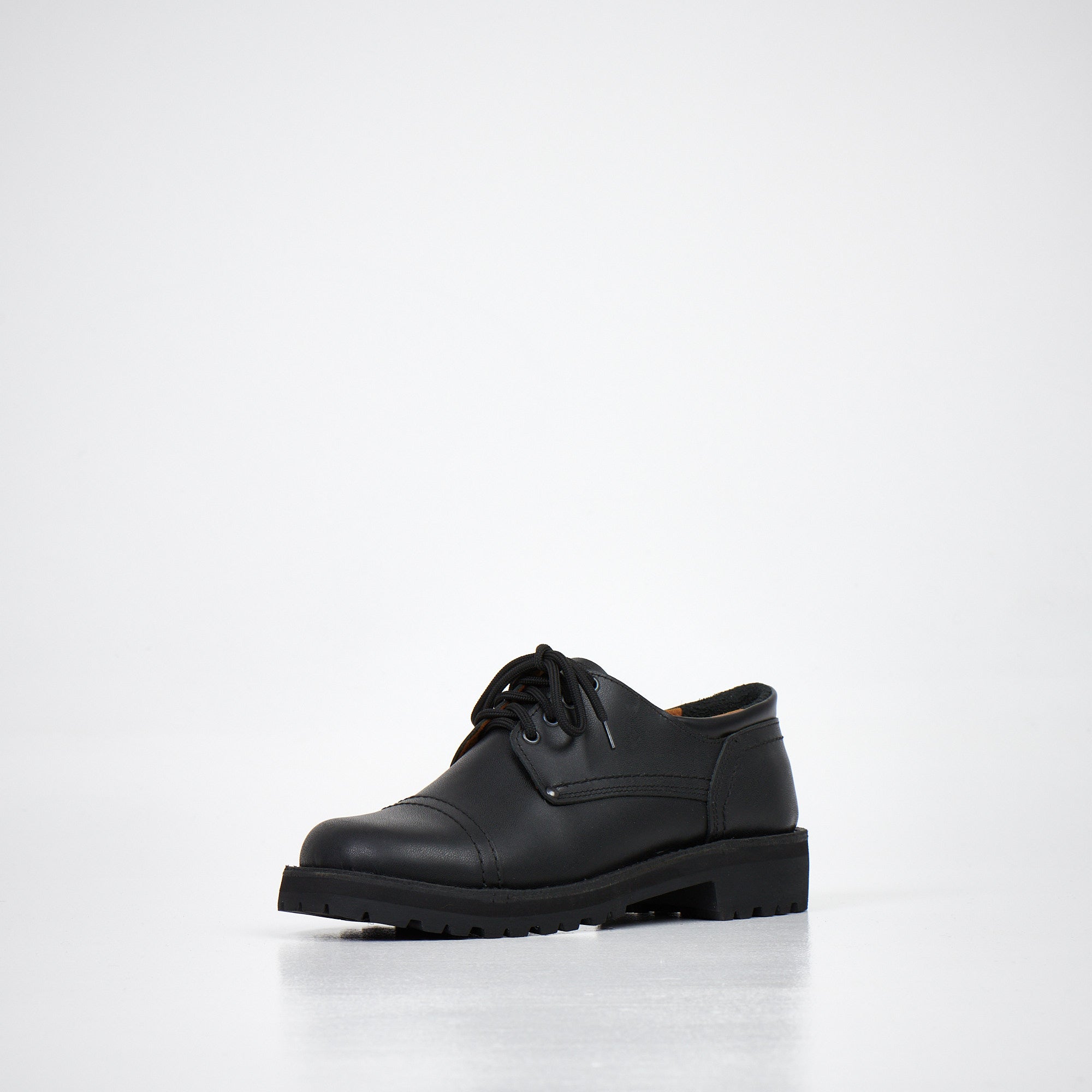 Chaussures derby en cuir noir fait main, vue de face sur parquet