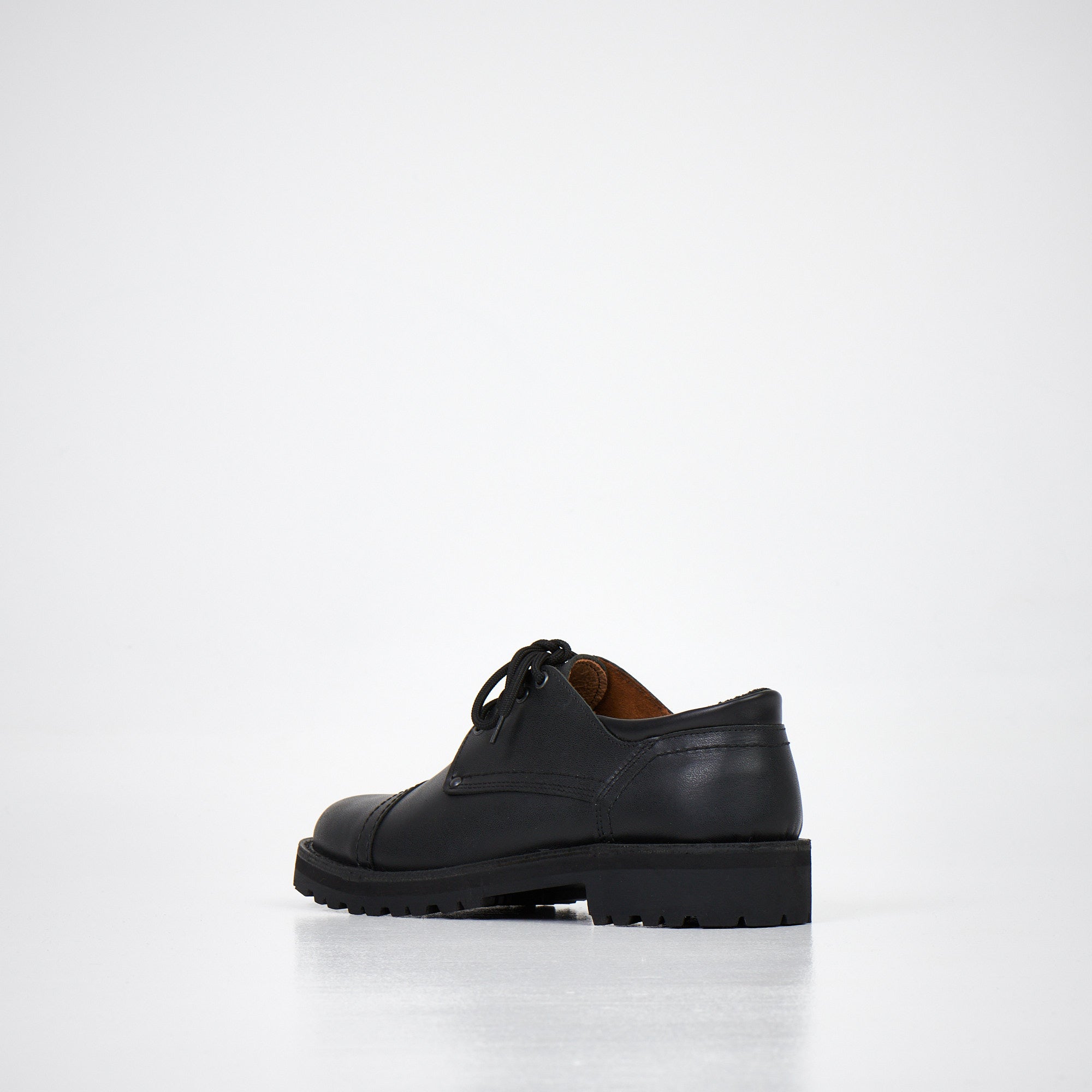 Chaussures derby en cuir noir fait main, détail des finitions et de la semelle