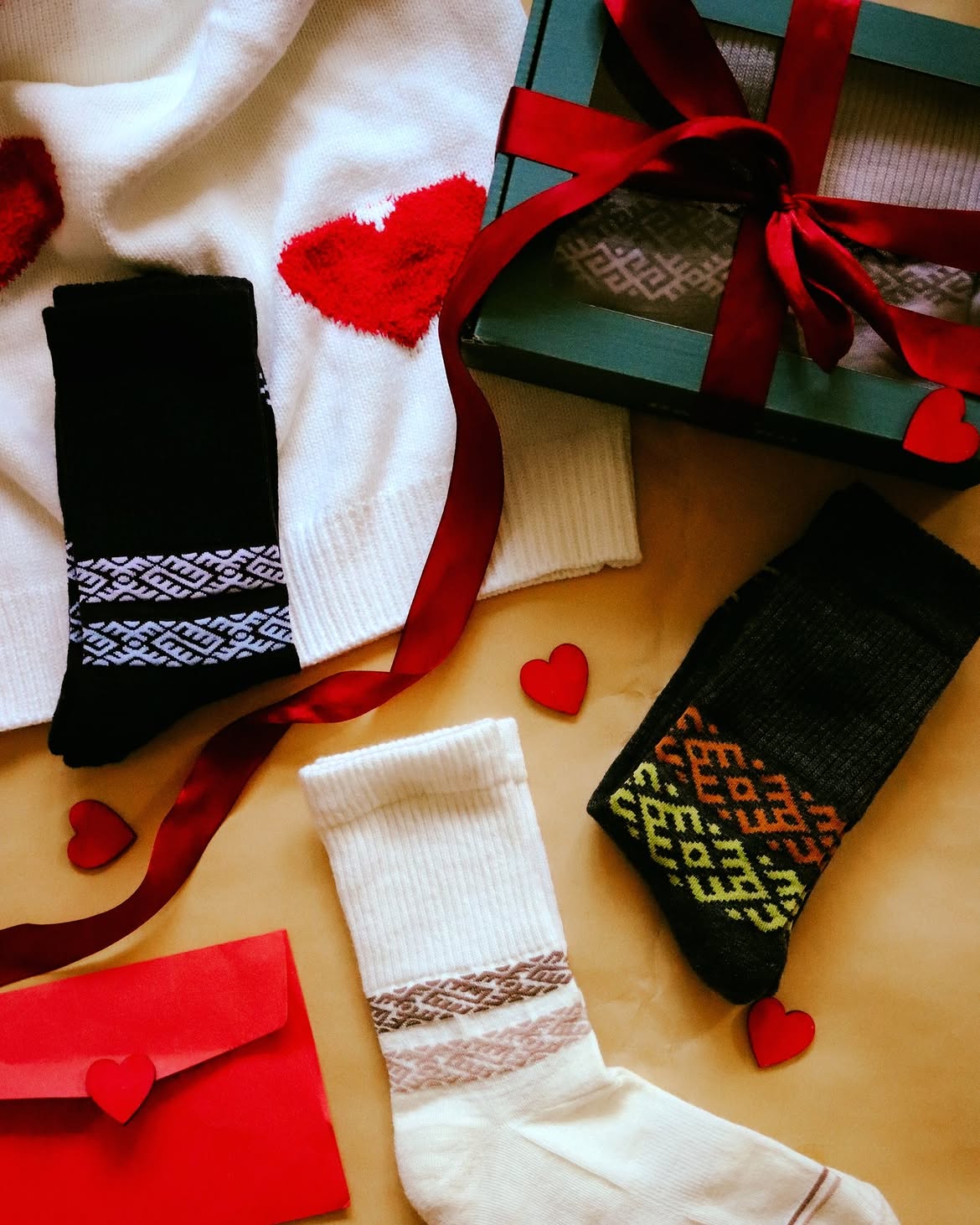 Chaussettes en laine mérinos blanches et noires à motifs présentées avec un coffret et un ruban rouge, Baltland