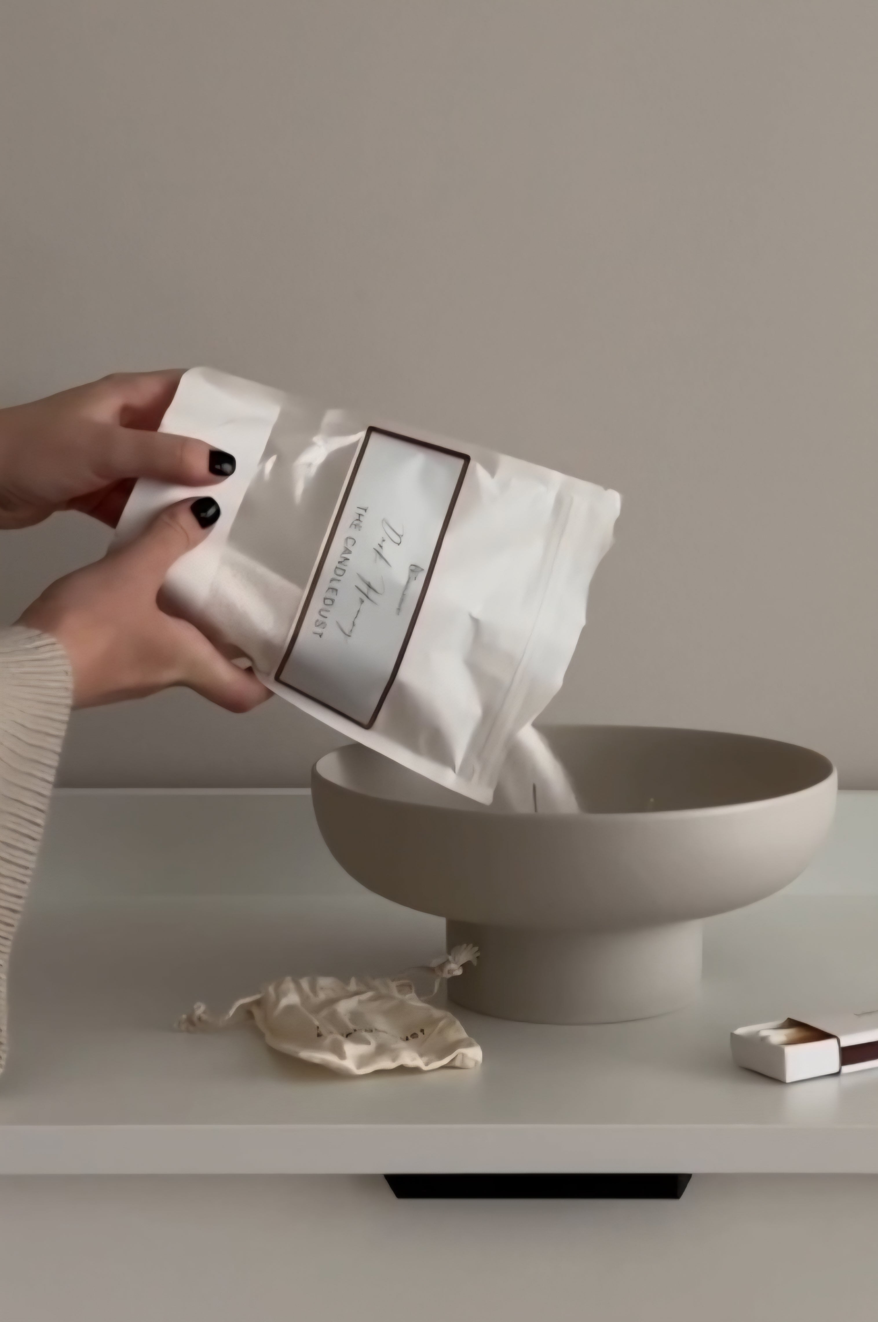 Versement de poudre Candledust dans un bol beige avec sachet et mèche