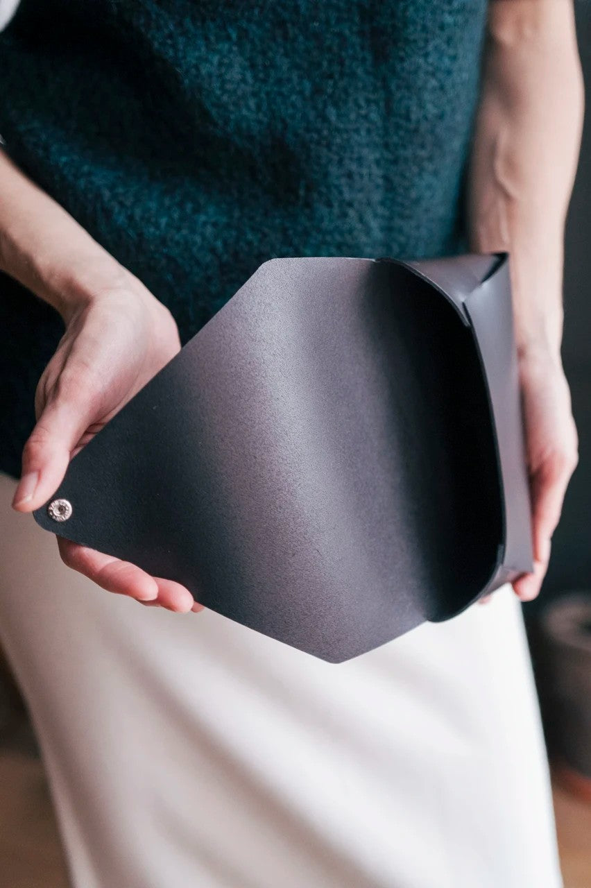 Pochette bandoulière en cuir noir Stella Soomlais, rabat ouvert montrant l'intérieur au tannage végétal