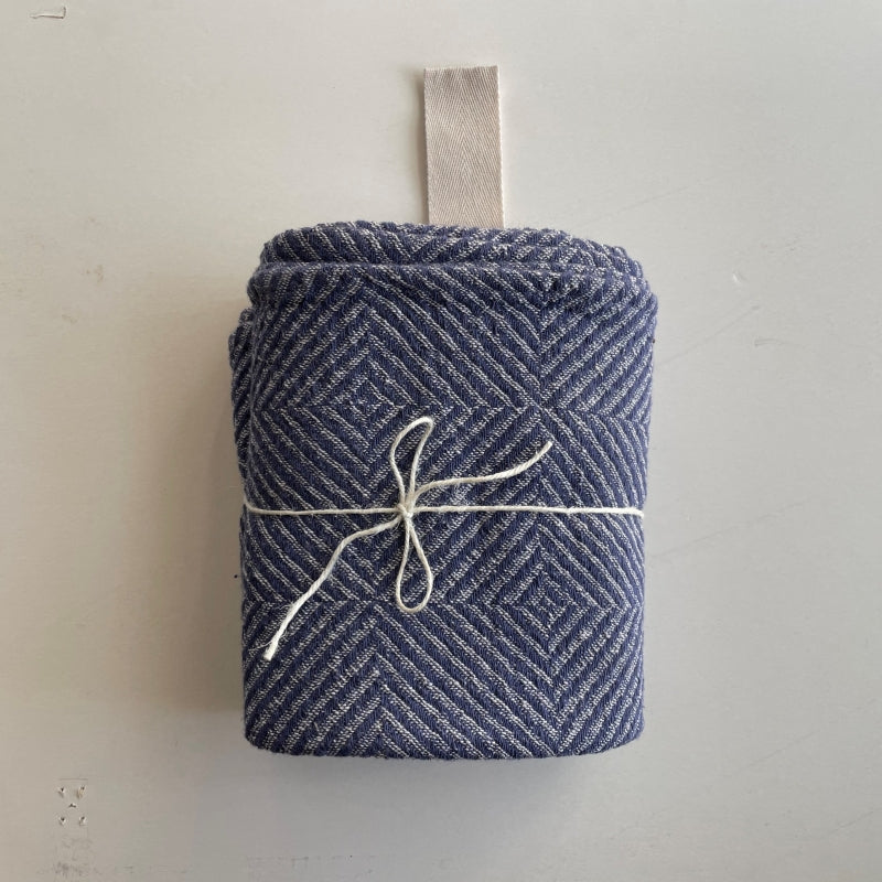 Grande serviette en lin Hertwill motif chevrons bleu, pliée et rangée