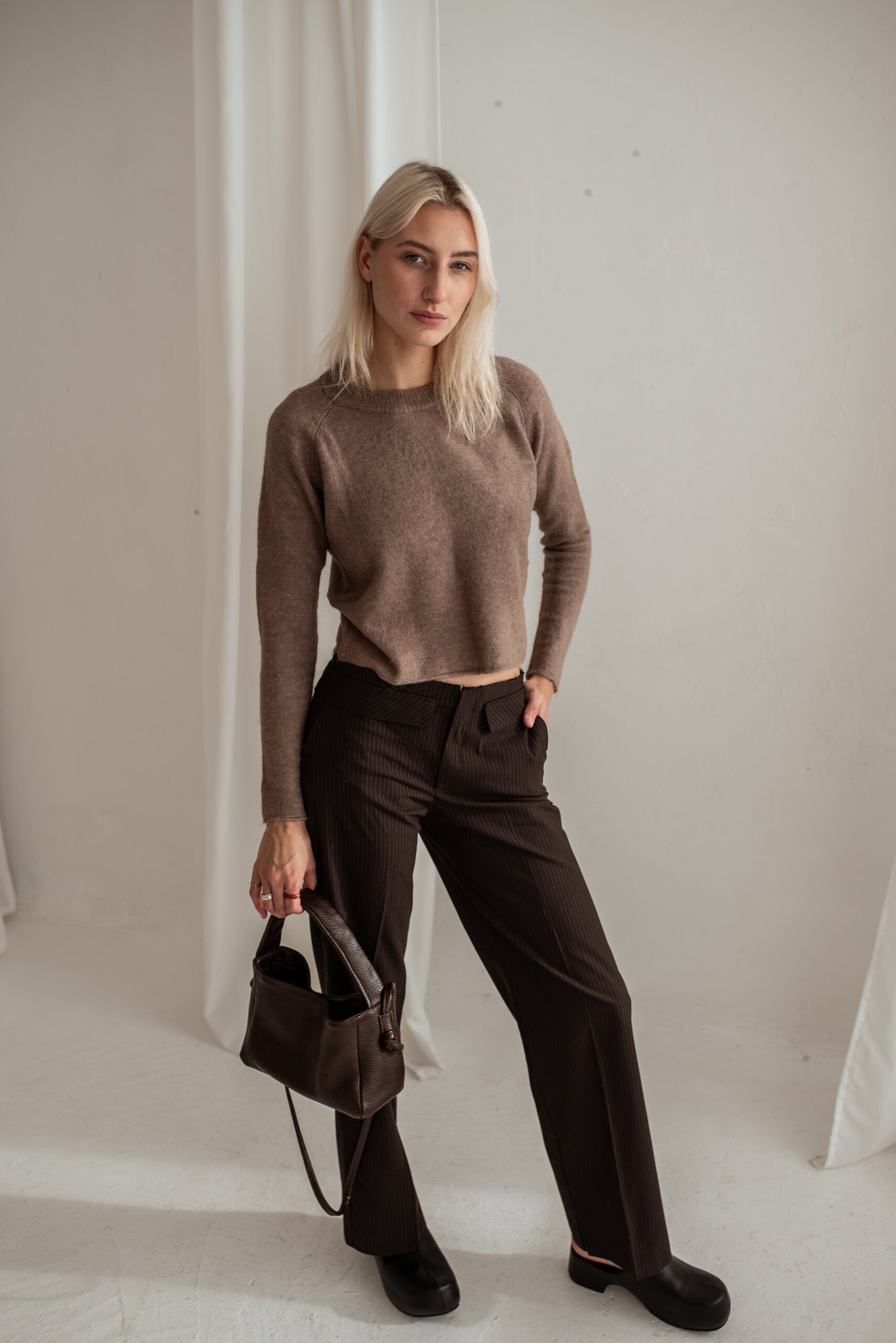 Sac crossbody en cuir marron foncé, vue de face, photo studio
