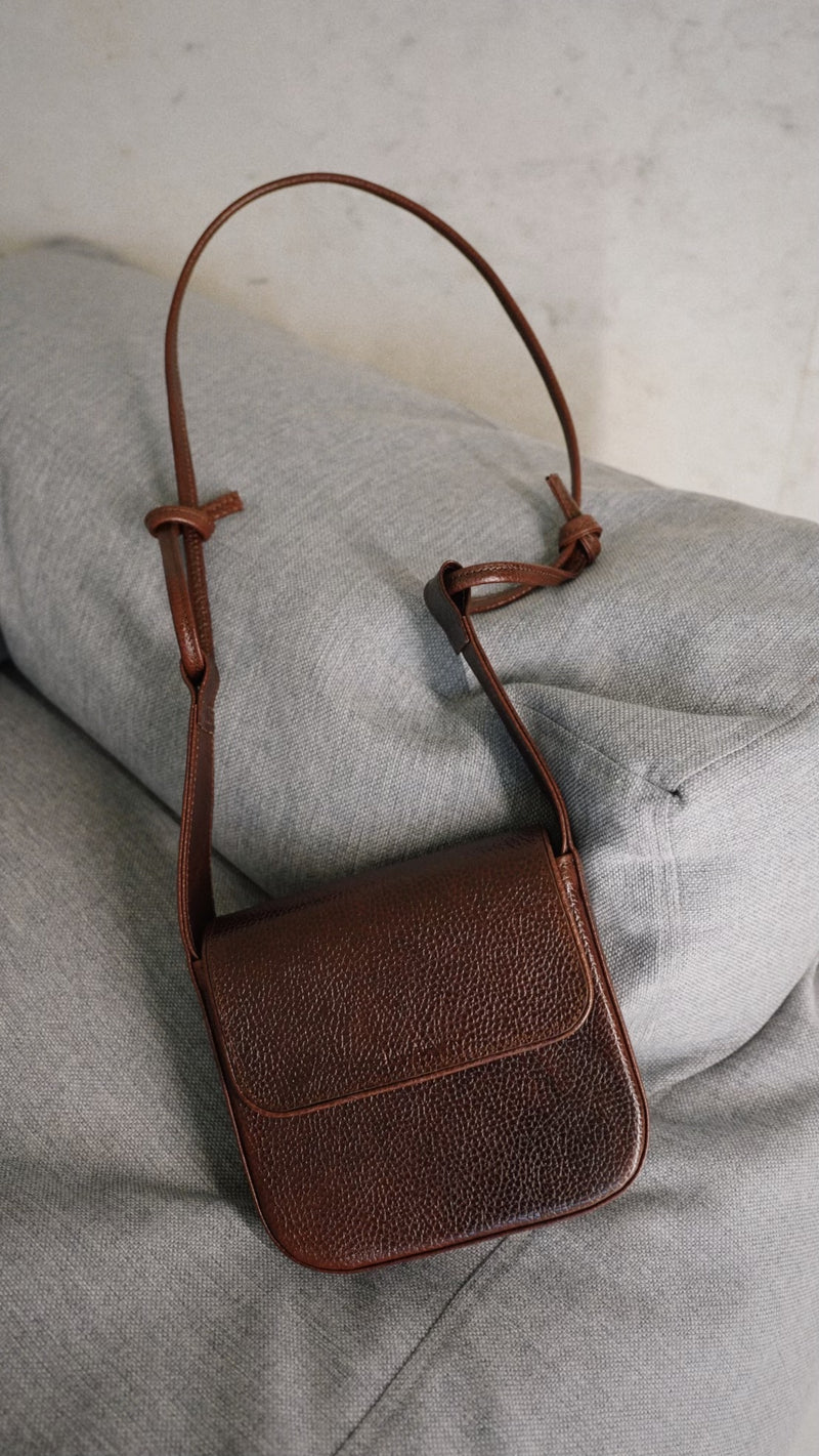 Sac bandoulière MUSA en cuir marron tanné naturel Lava Flow, porté en bandoulière studio