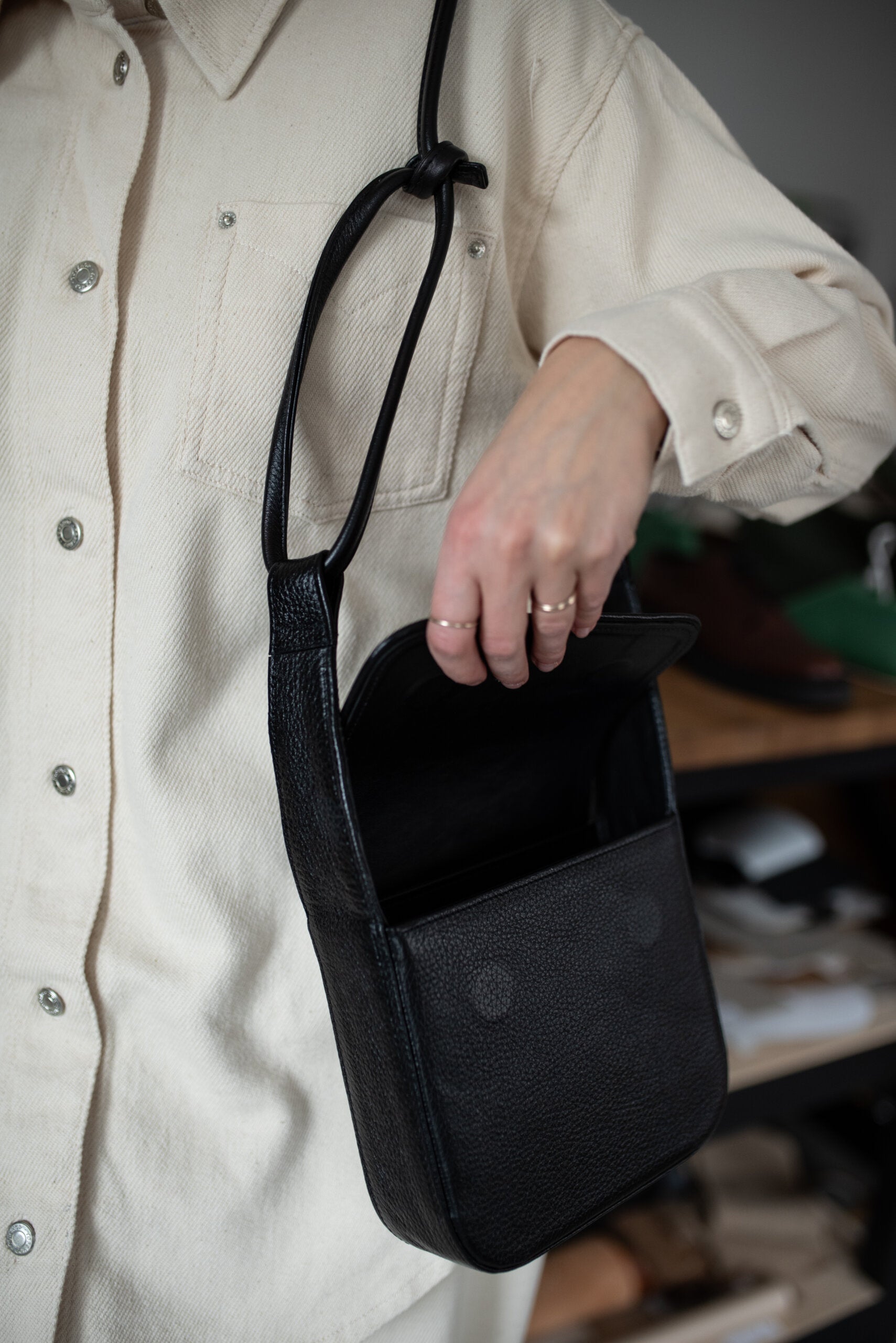 Sac bandoulière MUSA en cuir noir tanné naturel Lava Flow, vue de face avec fermoir éclair