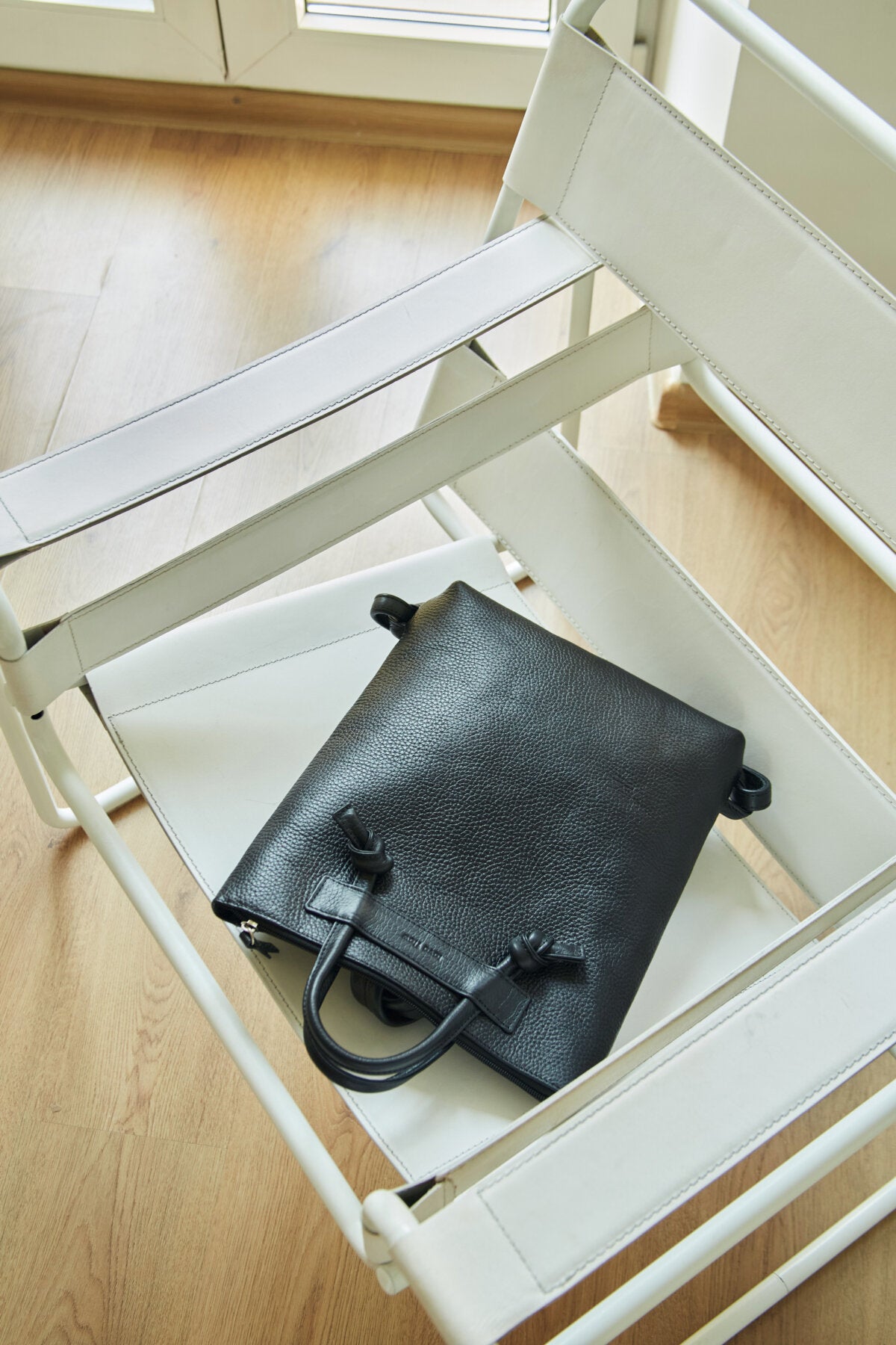 Sac à dos minimaliste en cuir marron, vue de dos, photo studio