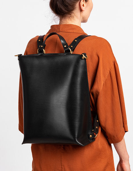 Sac à dos en cuir noir Stella Soomlais, porté au dos avec bretelles rivetées