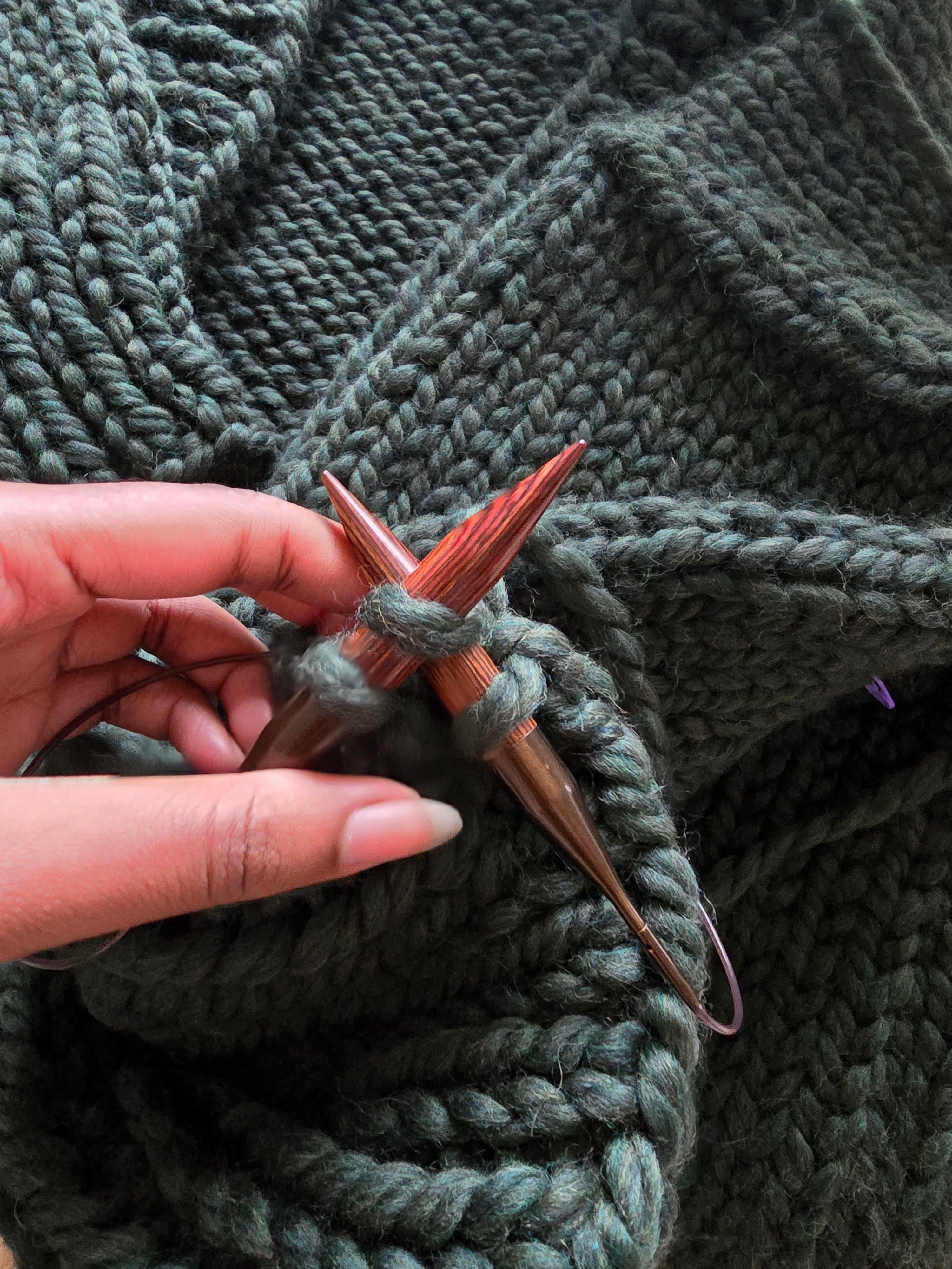 Cardigan en laine vert sapin tricoté main porté en lifestyle, gros plan sur le col et les mailles