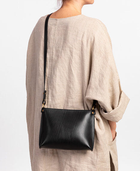 Sac à main en cuir noir Stella Soomlais porté en bandoulière, vue de dos