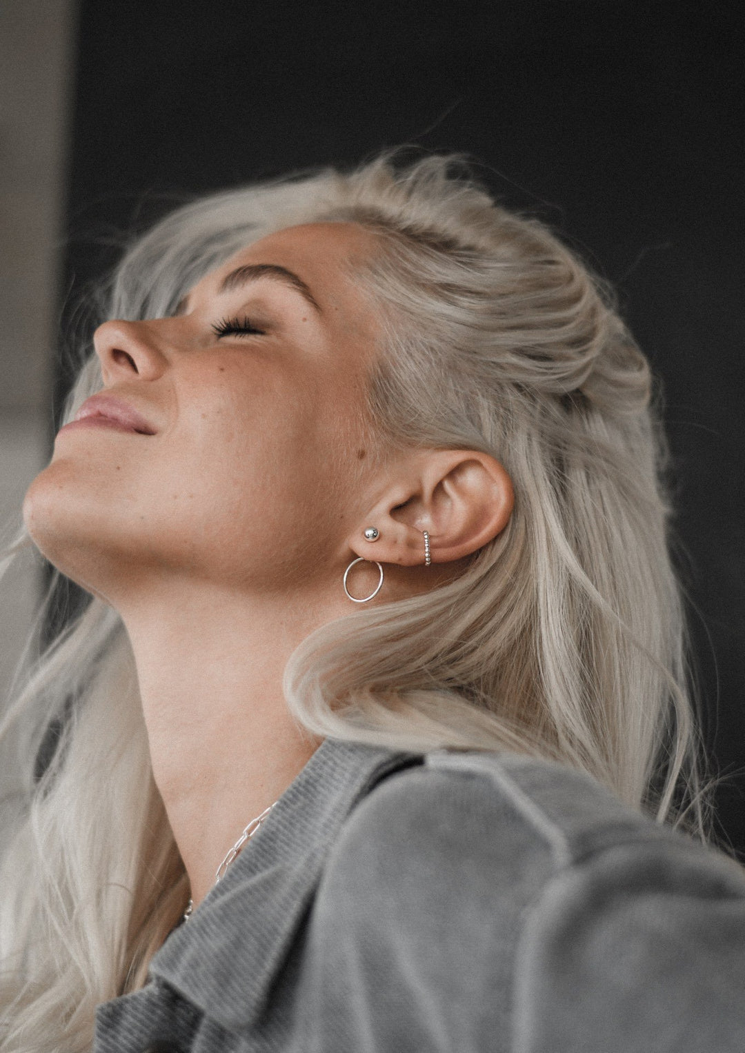 Boucles d'oreilles NO MORE Chord en argent sterling, portées par femme blonde souriante