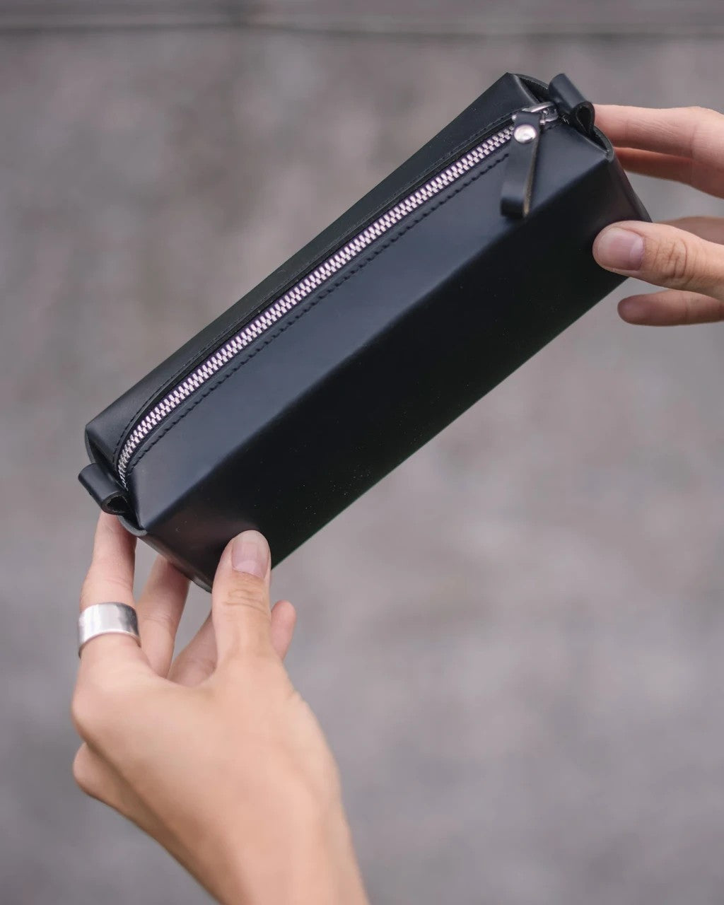 Trousse en cuir noir Single-Decker Stella Soomlais, tenue à deux mains avec zip argenté fermé