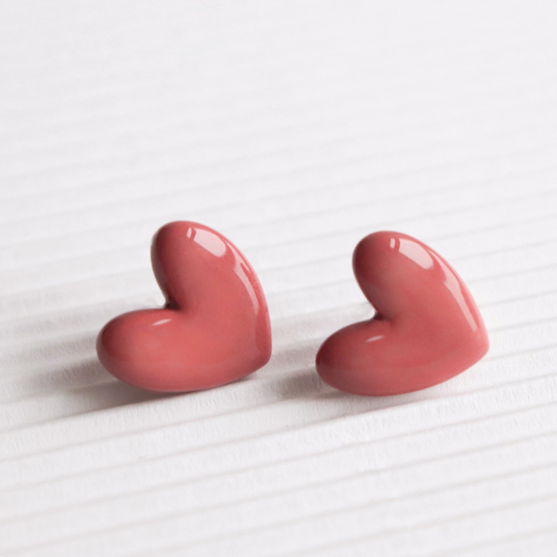 Puces d'oreilles cœur en porcelaine rose, vue éditoriale