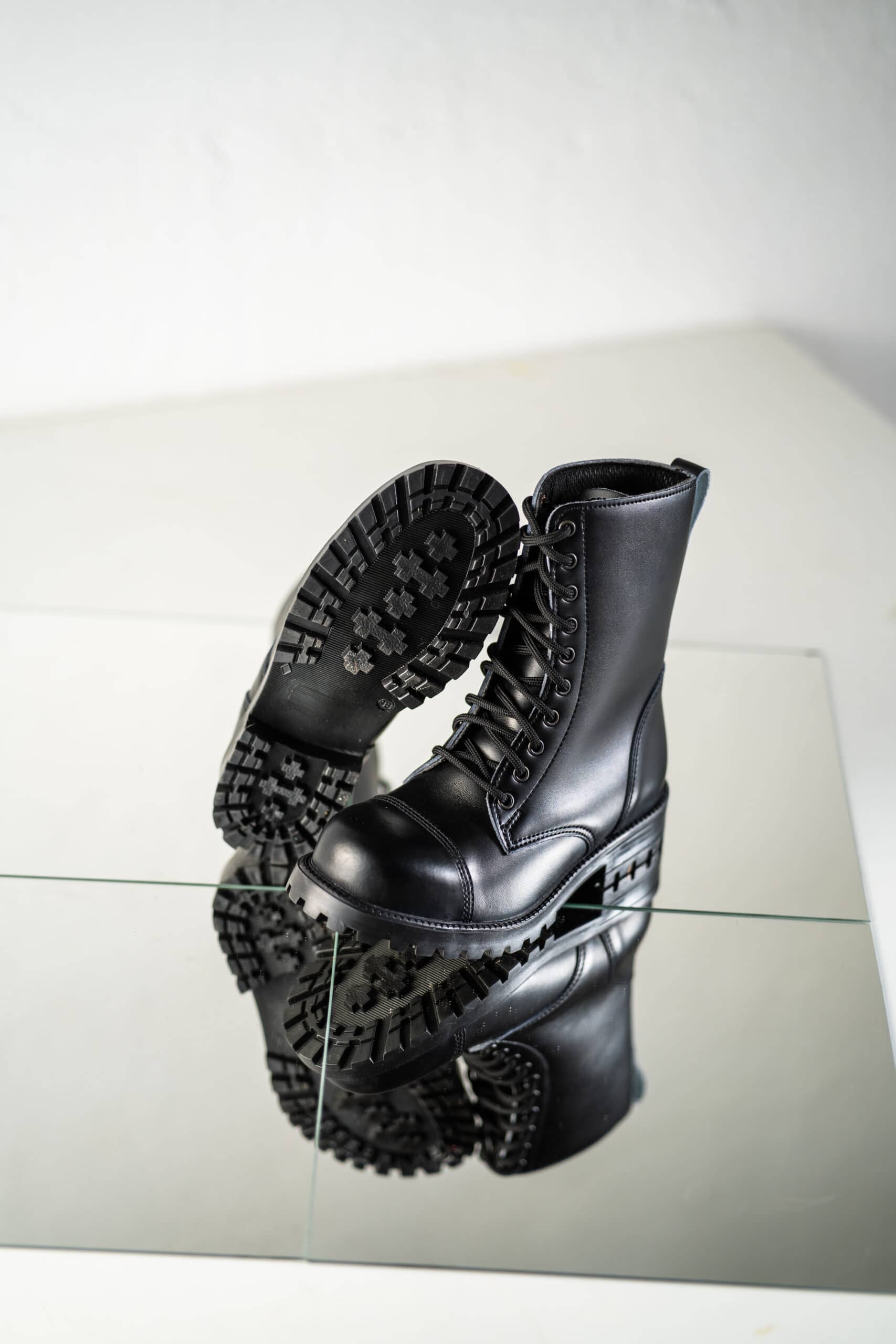 Bottines en cuir noir à semelle crantée, pied en l'air vue latérale
