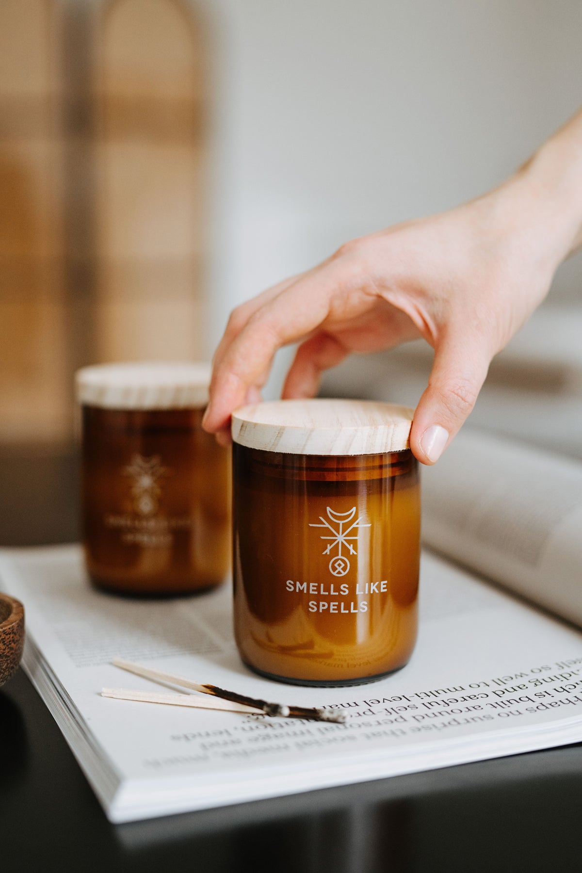 Bougie parfumée en verre ambré Smells Like Spells, vue lifestyle ambiance contemplative