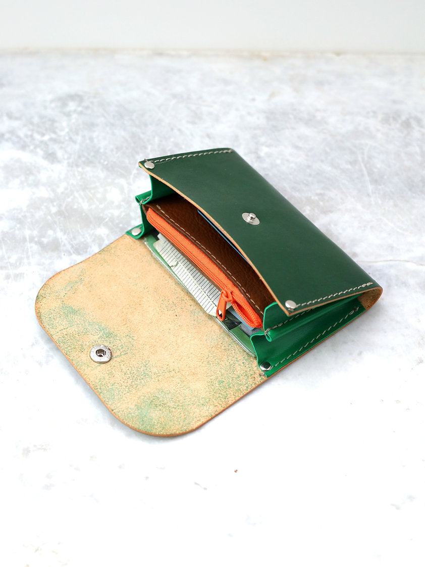 Portefeuille FRIDAY TOKS VISOKS en cuir vert sapin, ouvert sur intérieur orange et compartiment zippé