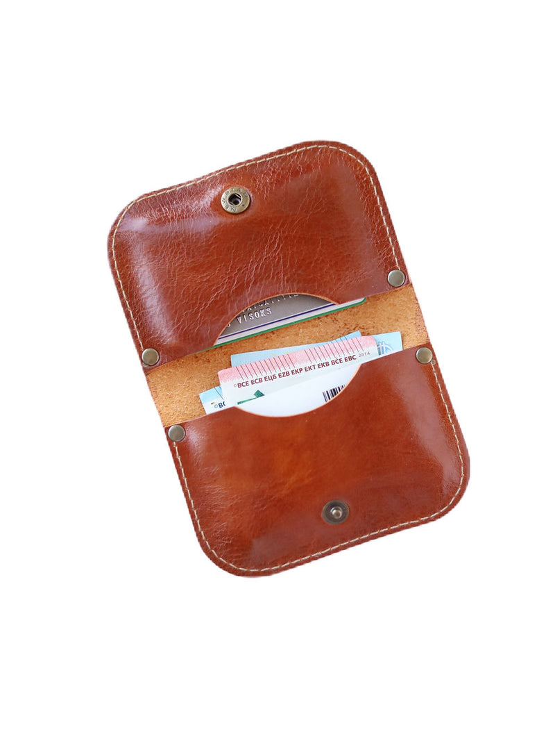 Portefeuille en cuir marron doré brillant tenu en main, détails de finition