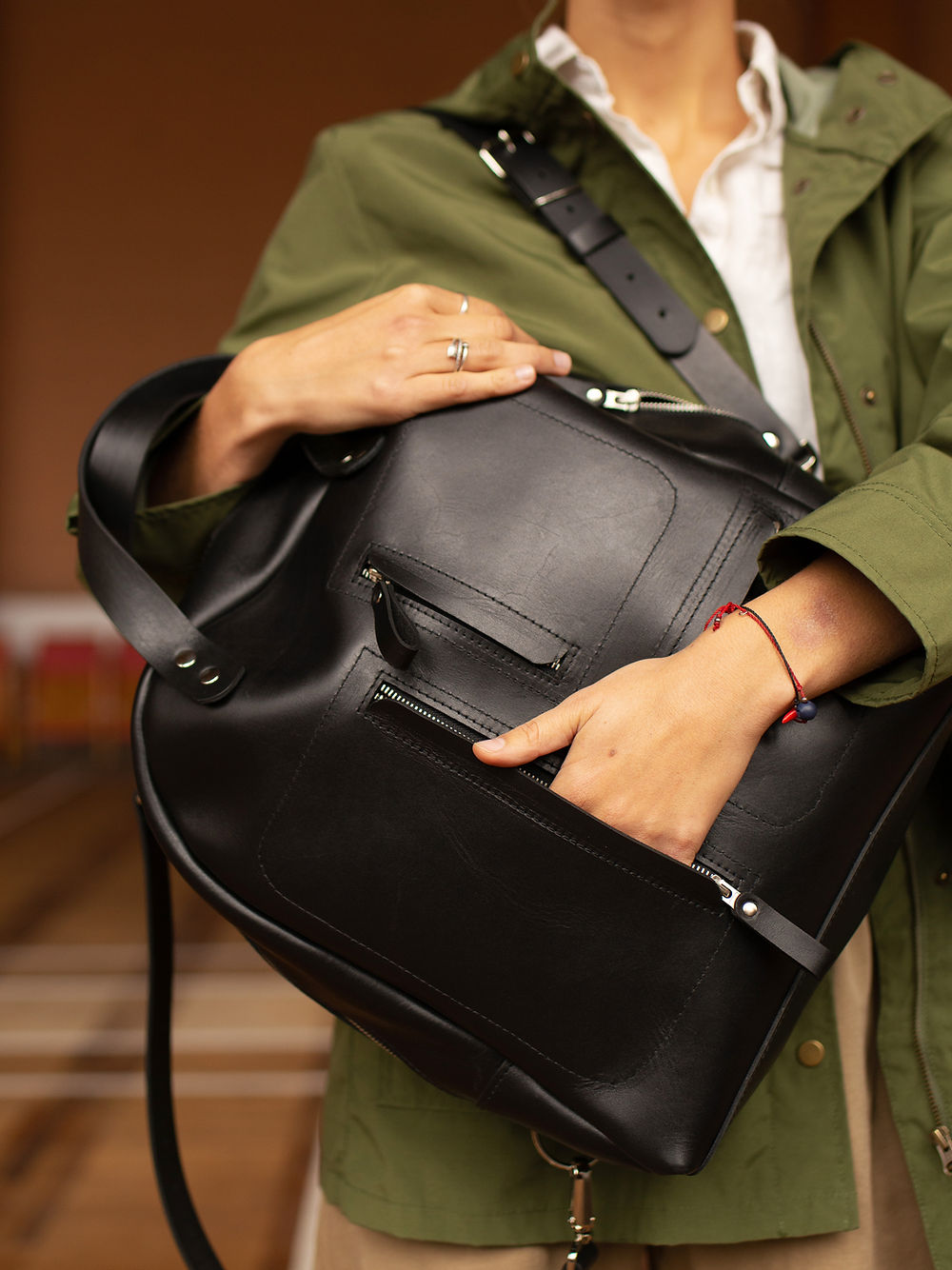 Sac à dos en cuir noir porté sur l'épaule, ambiance urbaine