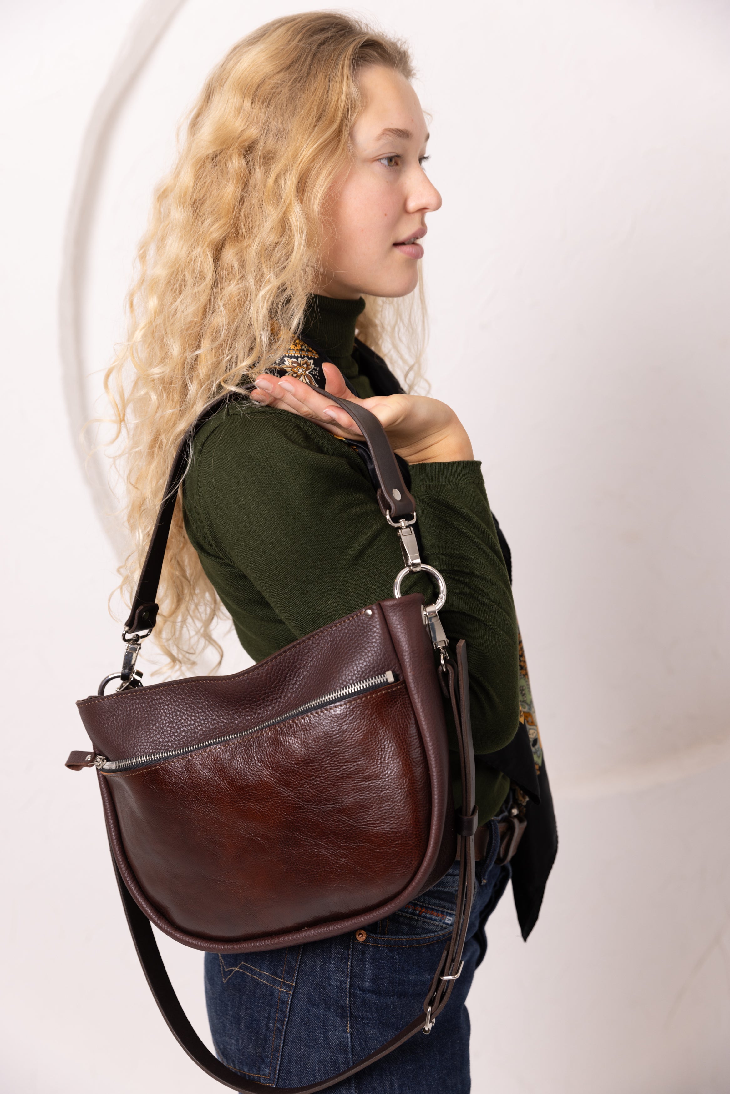 Sac à main STELLA TOKS VISOKS en cuir cognac et daim marron, porté à l'épaule sur pull vert