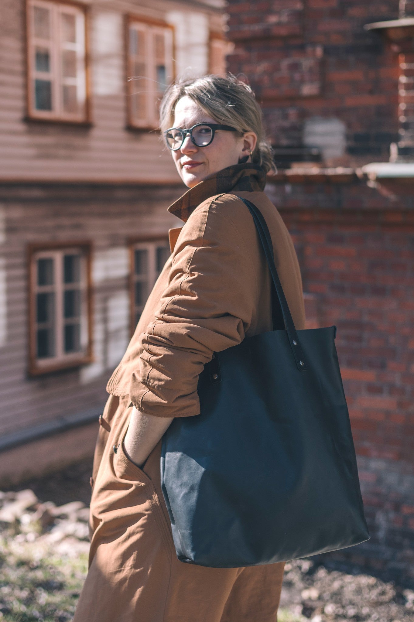 Sac cabas en cuir noir Stella Soomlais, porté à l'épaule dans la rue
