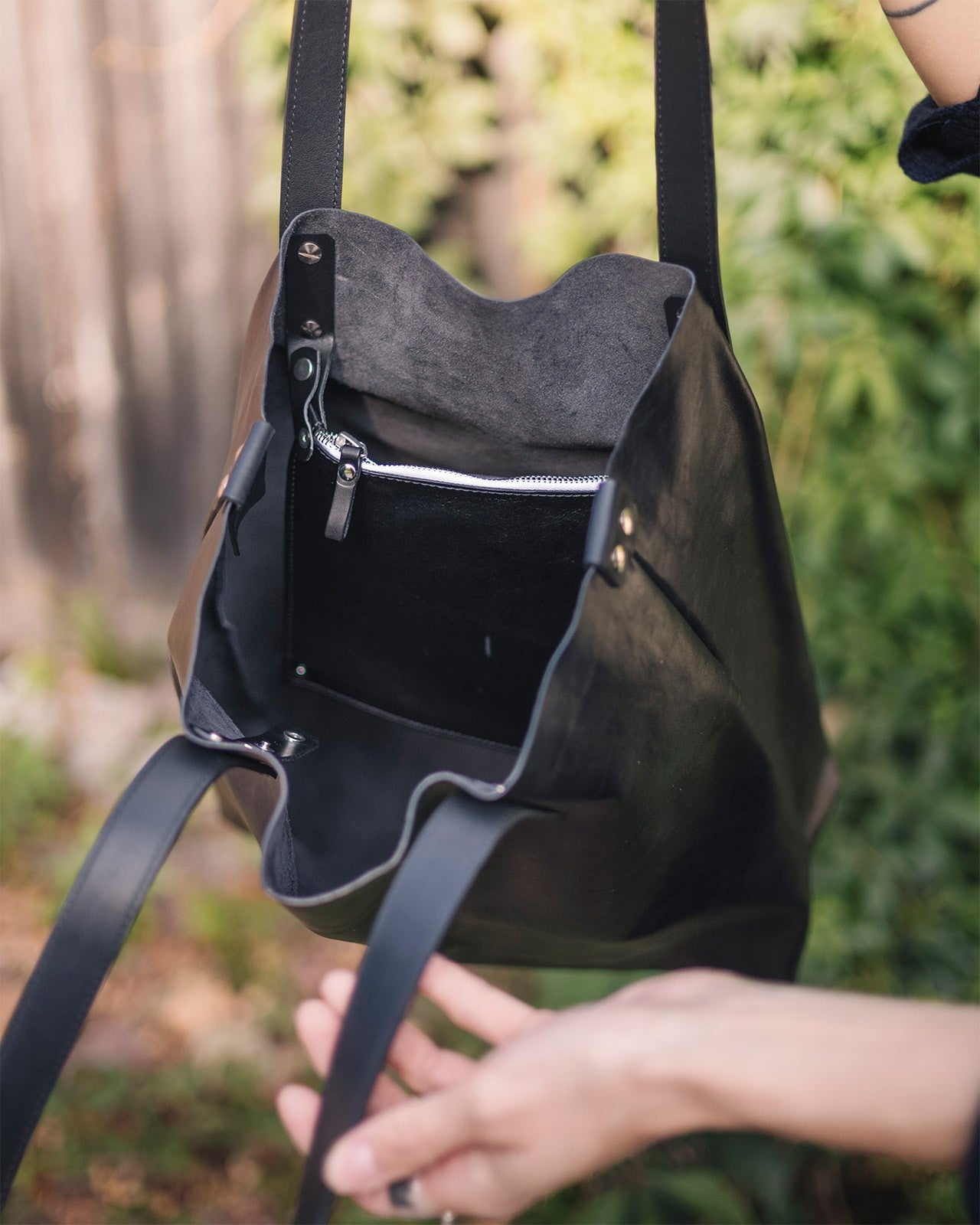 Sac cabas en cuir noir Stella Soomlais, ouvert sur la pochette zippée fixée à l'intérieur