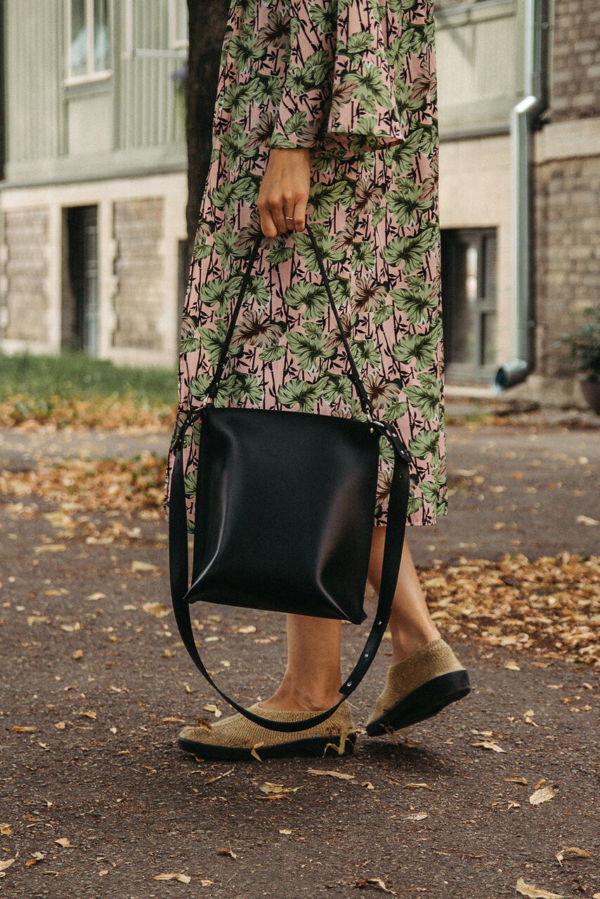 Sac à main en cuir noir Stella Soomlais, tenu par les anses courtes, bandoulière détachée