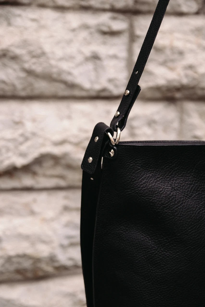 Sac à main en cuir noir Stella Soomlais, détail de l'attache et des rivets de la bandoulière